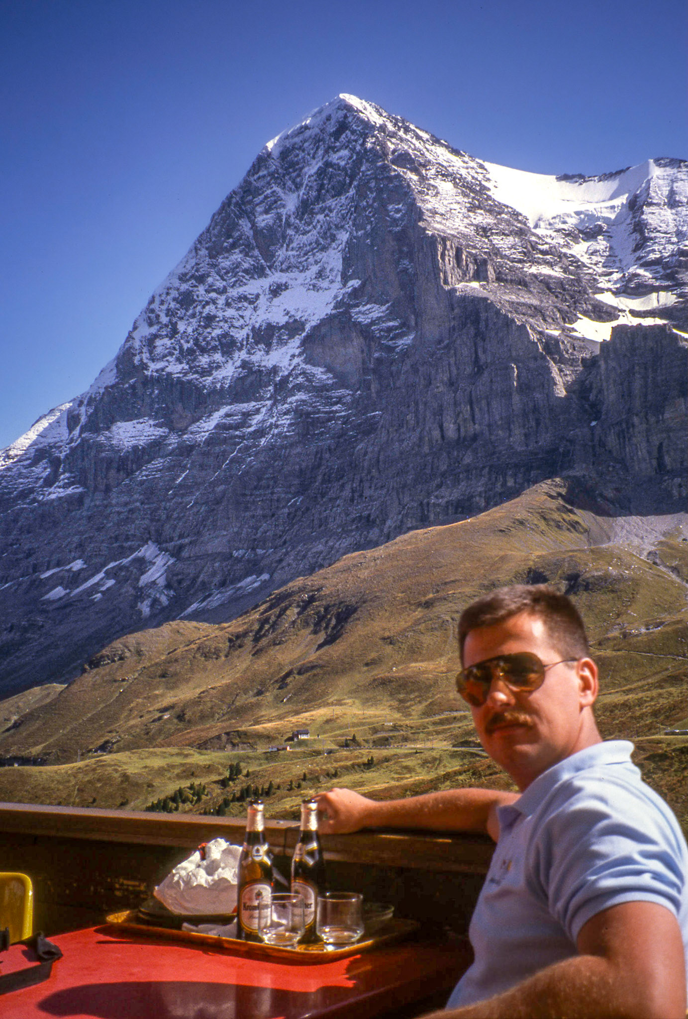 Circa 1993: Brian Huculak enjoying a beer in Grindelwald and a view of the north face of Mt. Eiger trekking through the Bernese Alps, Switzerland. Photo credit: Robert Keith