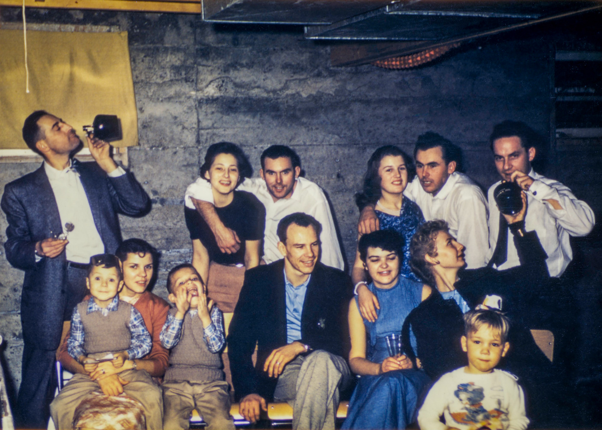 1 January 1958 • New Years House party, likely Edmonton, AB. L to R back row: unknown male with bottle - Katheen [Shewchuk] Huculak (24) with husband John Huculak (25). Ricky (Erika) [Brom] Huculak (18) with husband George Huculak (26, John's Brother). Others in photo unknown.