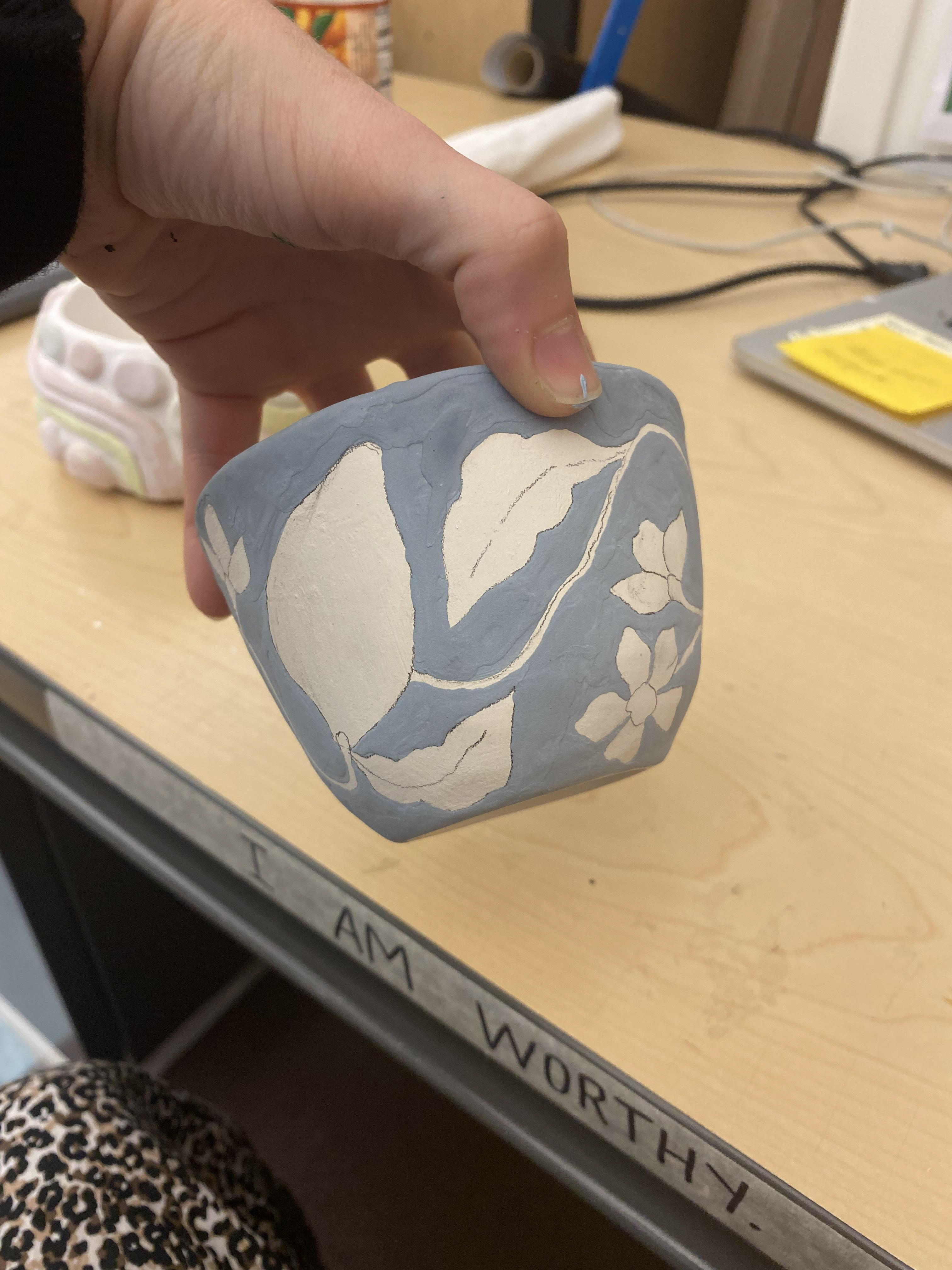 After hand building the pinch pot planter (this part was very messy- no photos sadly), the pot was then bisque fired. Once out of the kiln I began to sketch with pencil and paint gloss glaze.