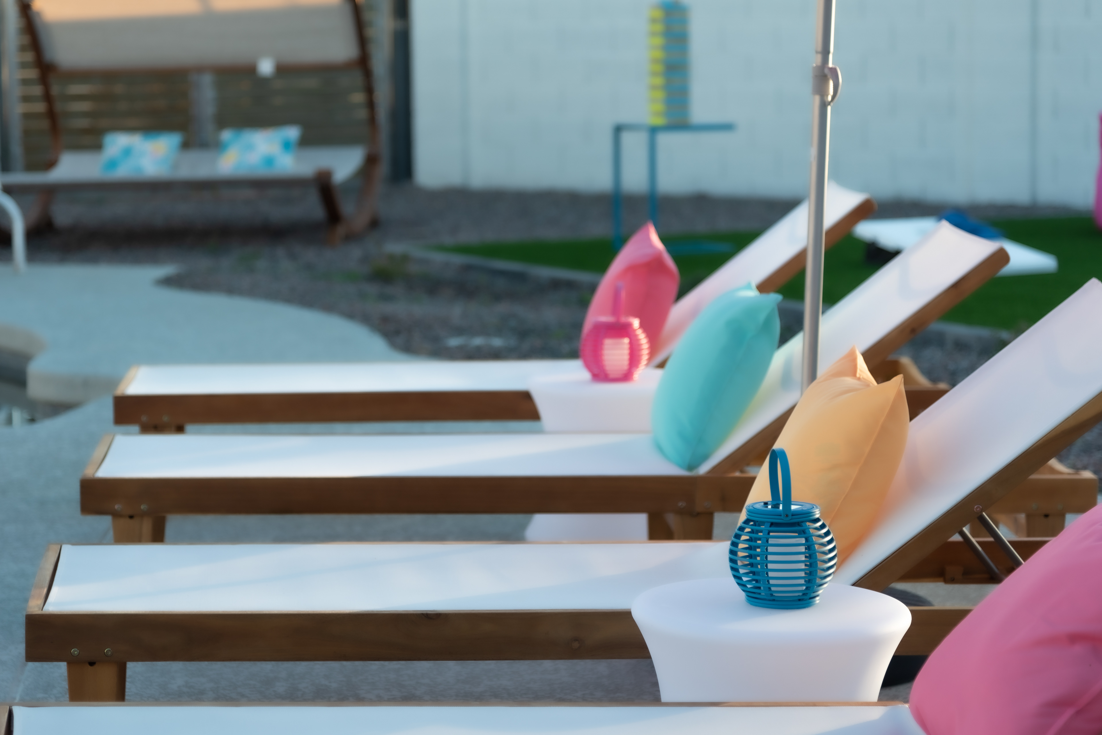 Pool loungers with pink and teal pillows