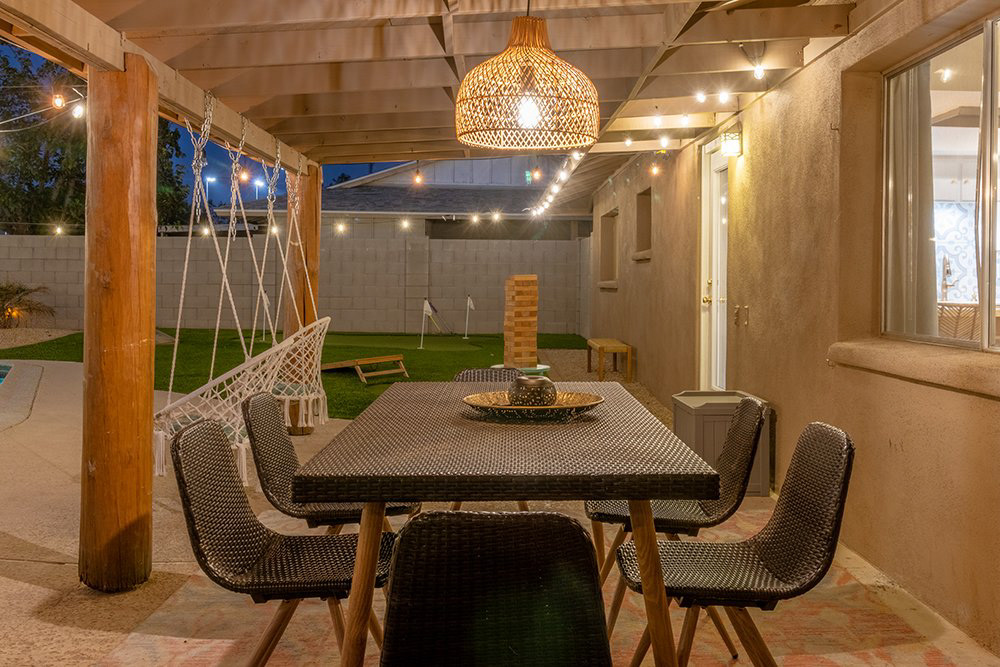 Covered patio dining table under string lights