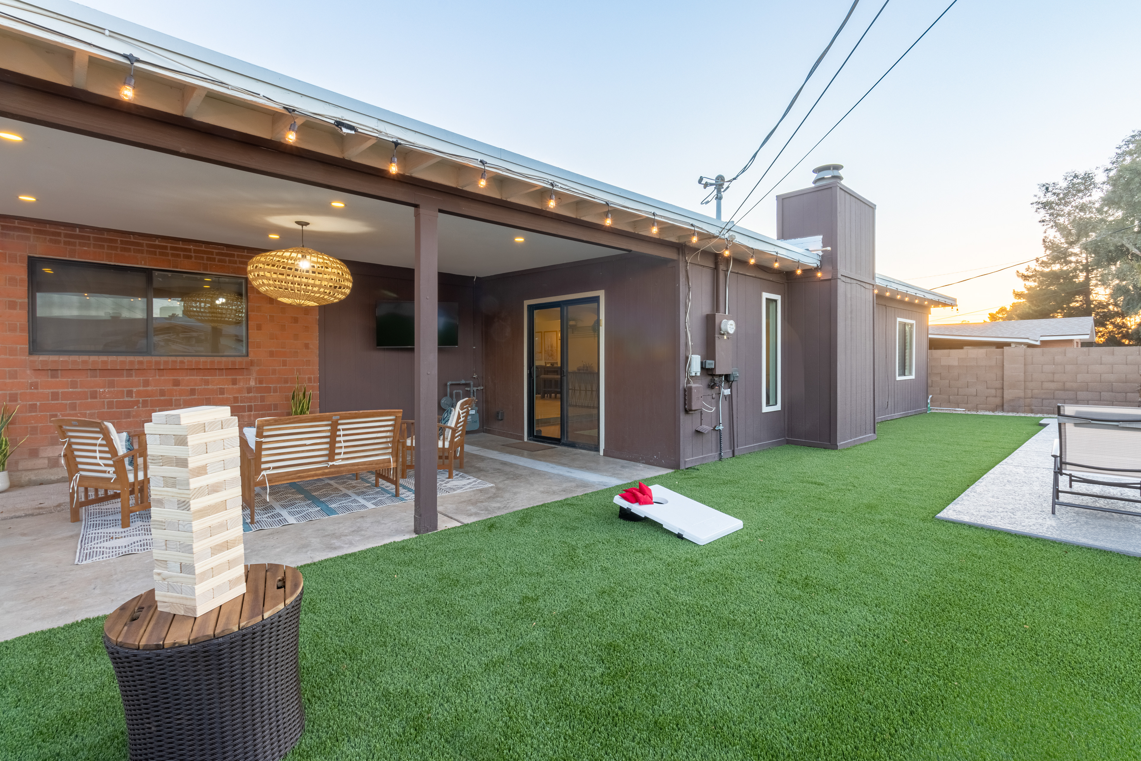 Covered patio with cornhole and string lights