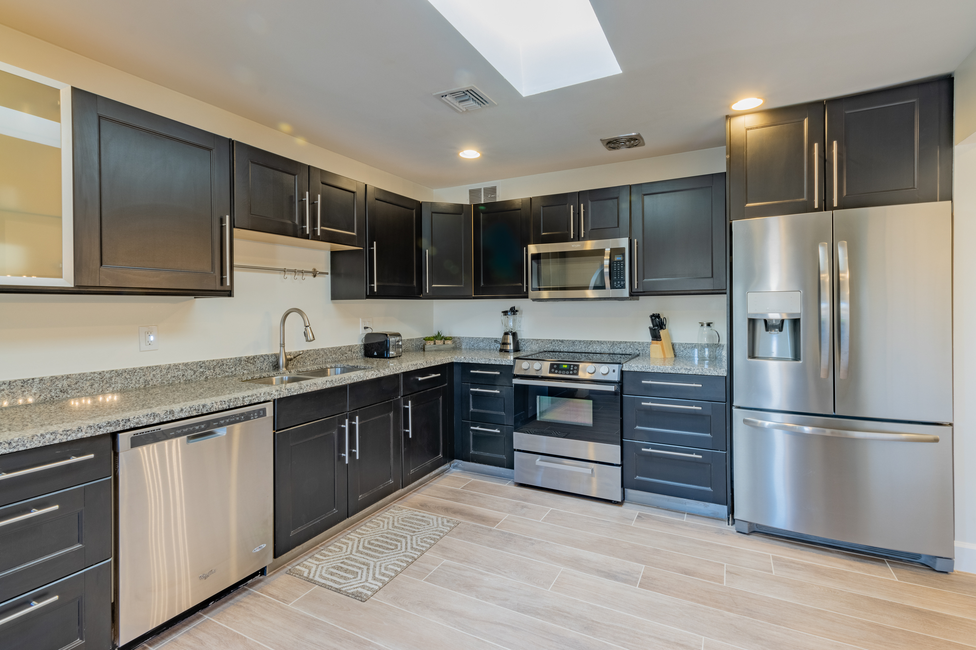 Kitchen with dark cabinets and stainless appliances
