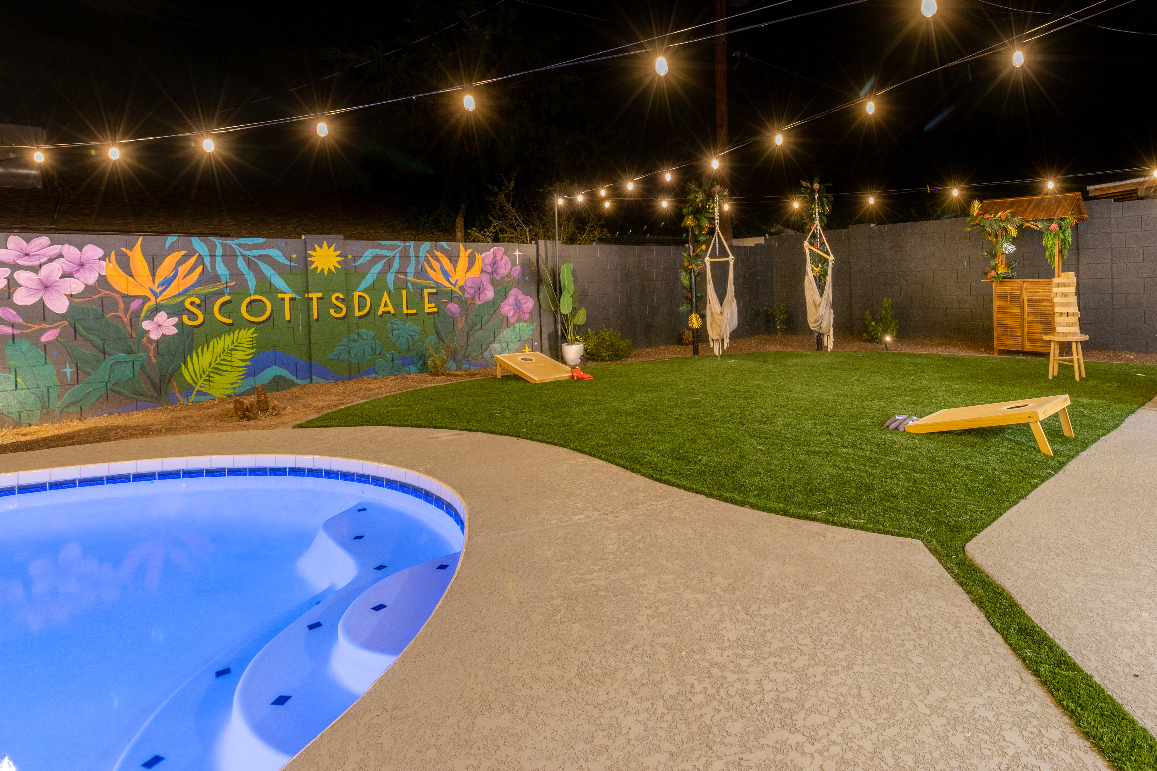 Lit pool and mural at night