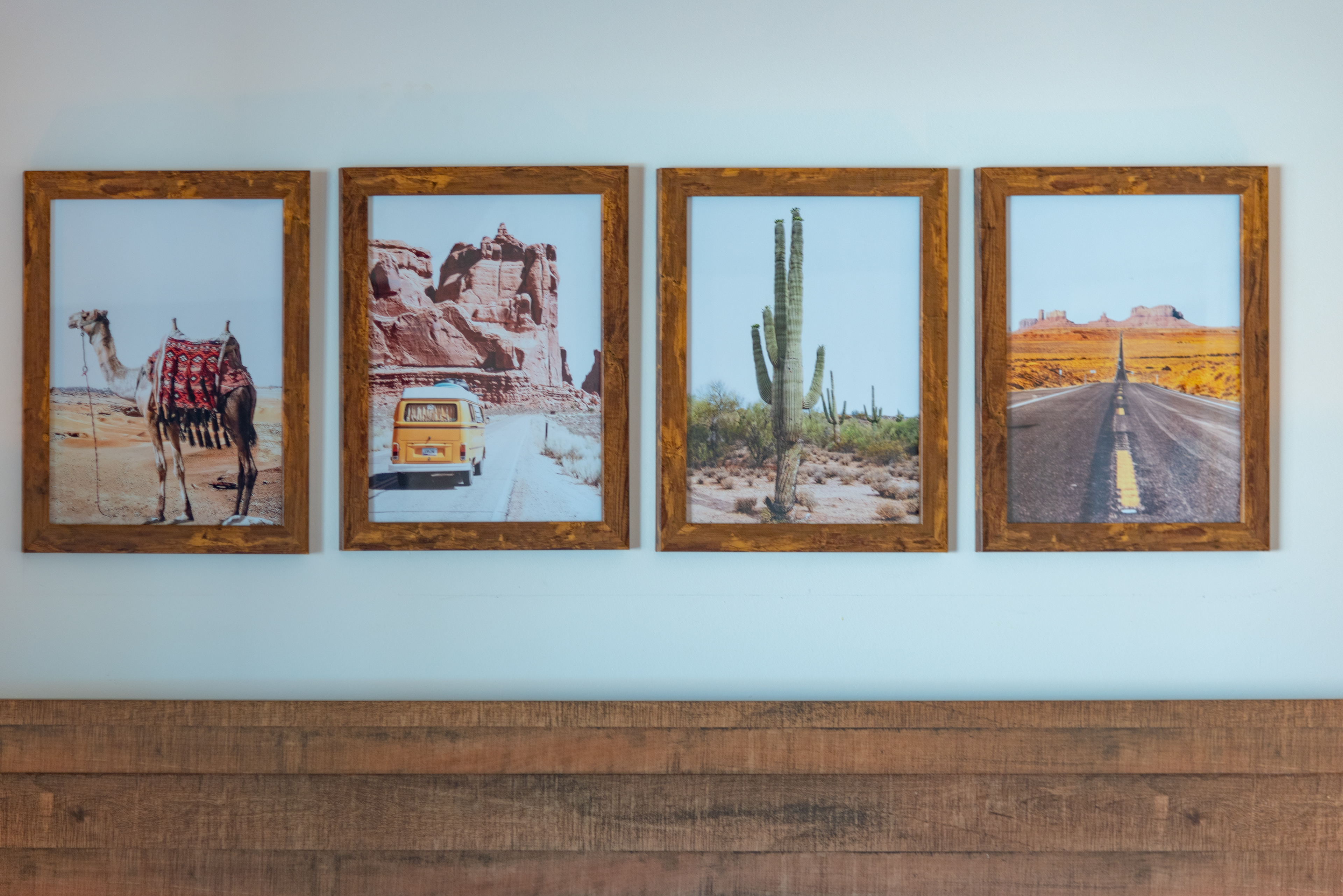 Framed desert prints above a bed