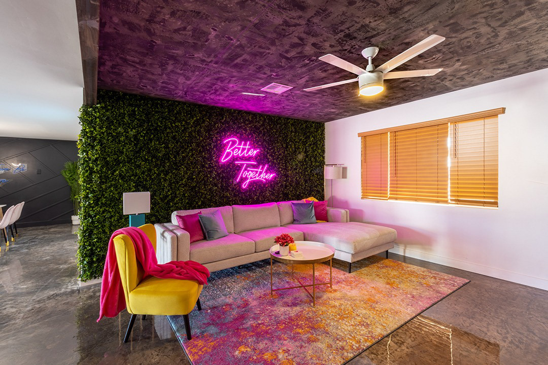 Vacation rental living room with neon sign and living green wall