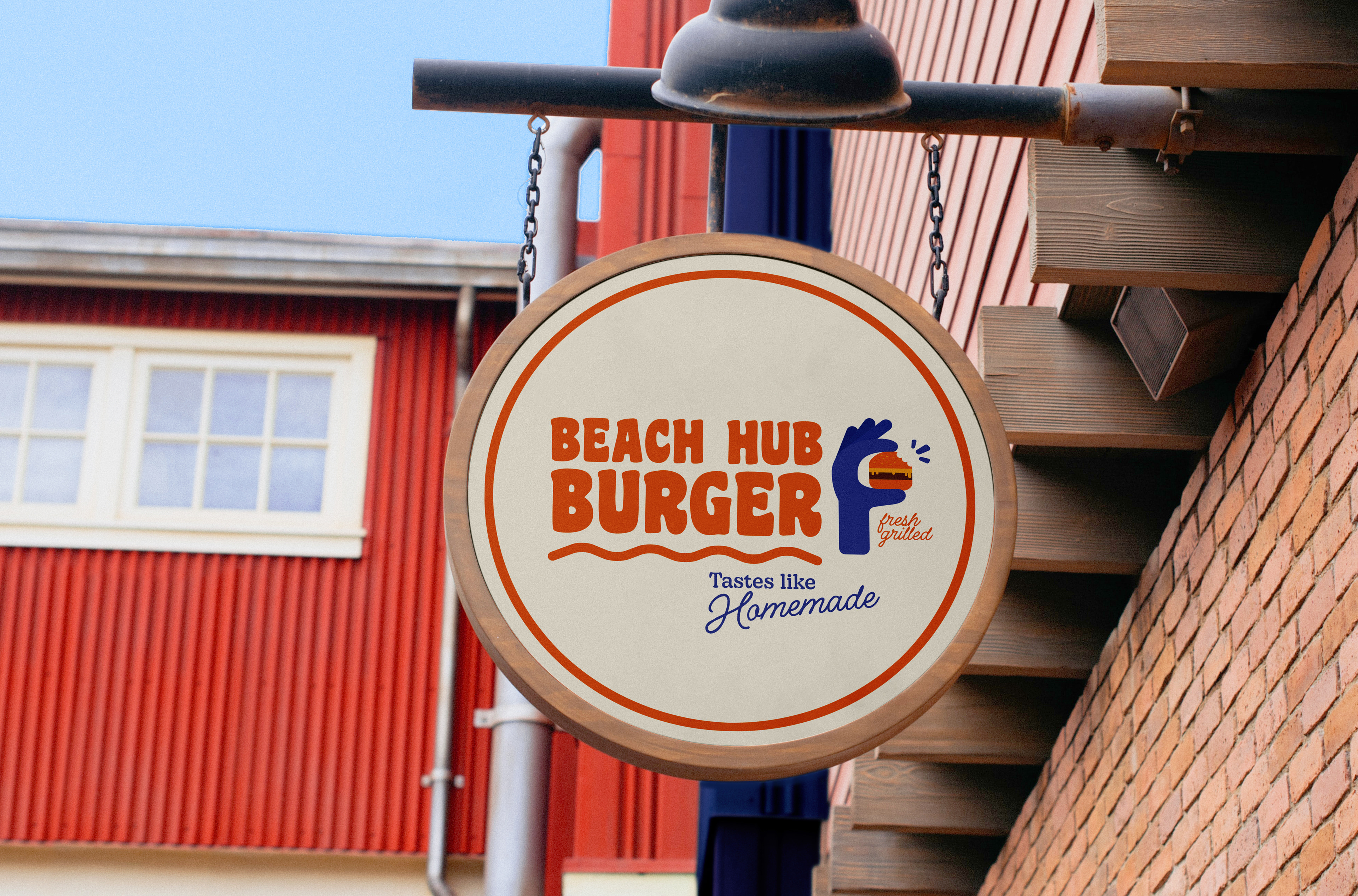 a hanging round sign with the logo Beach Hub Burger in front of the restaurant