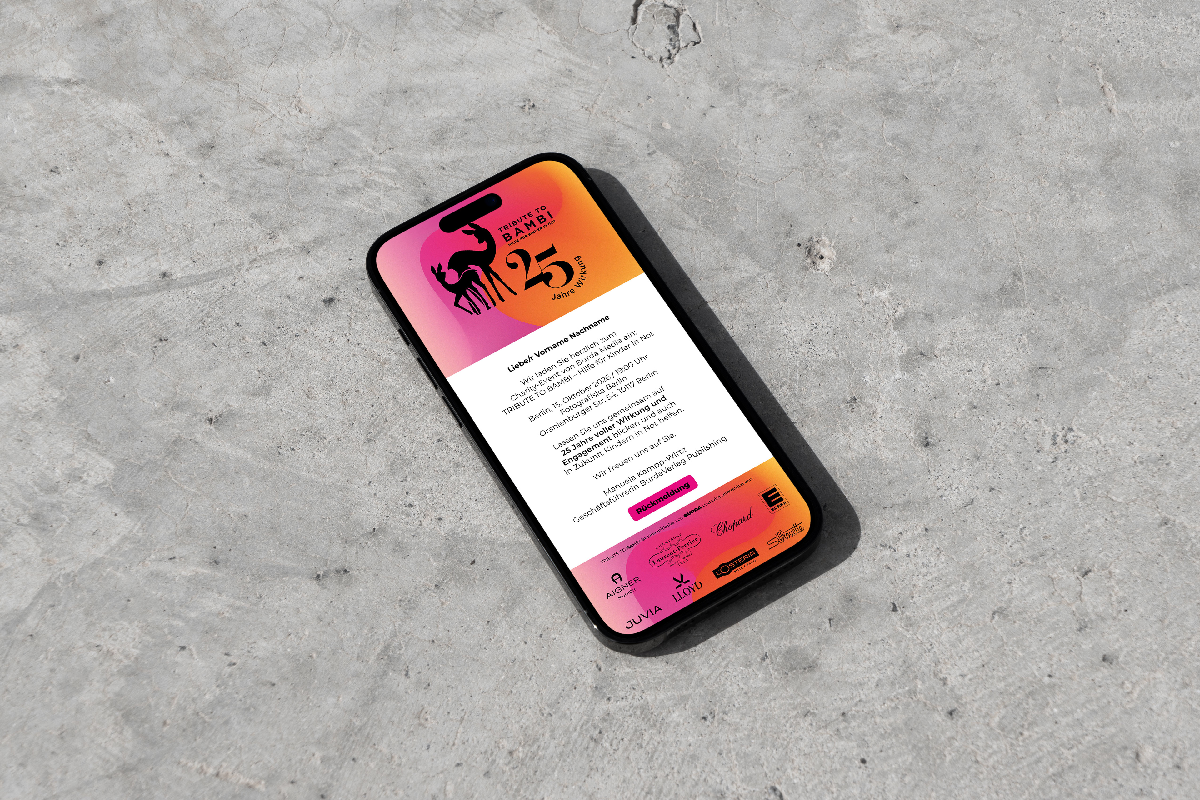 Smartphone liegt auf Betonfläche und zeigt die E-Mail Einladung für die Tribute to Bambi 25 Jahre Jubiläums-Spendengala-Einladung.
