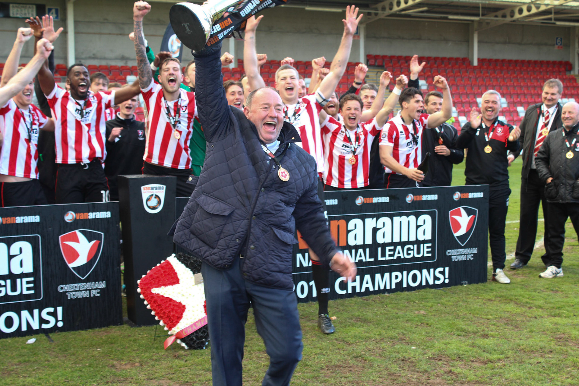 Gary Johnson holds the National League trophy and celebrates with Chetmeham Town team who are promoted to EFL League 2 in 2016