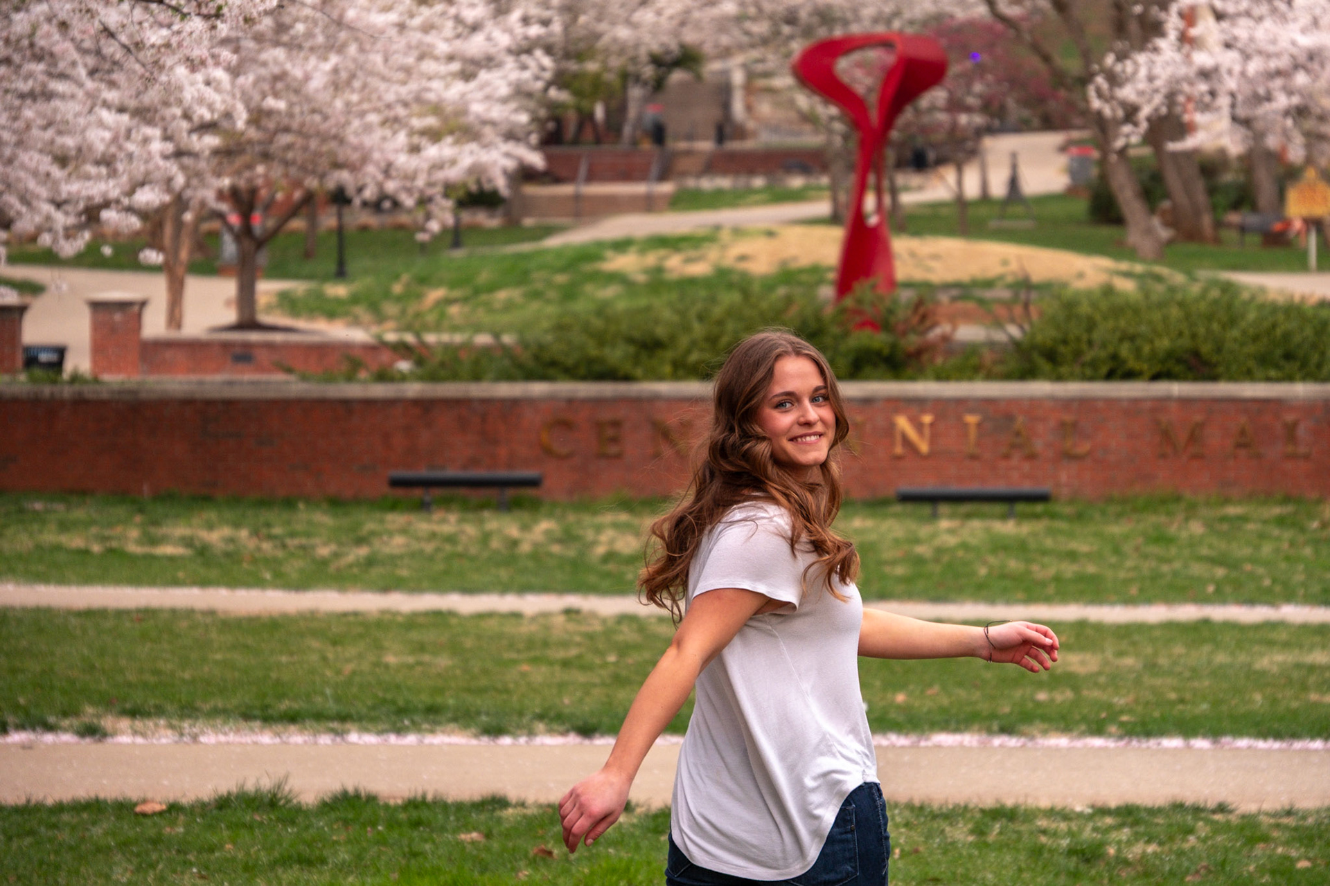 Olena Makhnovets, 18, poses in various locations across Western Kentucky University's campus on March 28, 2025. Following weeks of unpredictable weather, the campus was covered in white and pink as cherry blossom trees began to bloom.