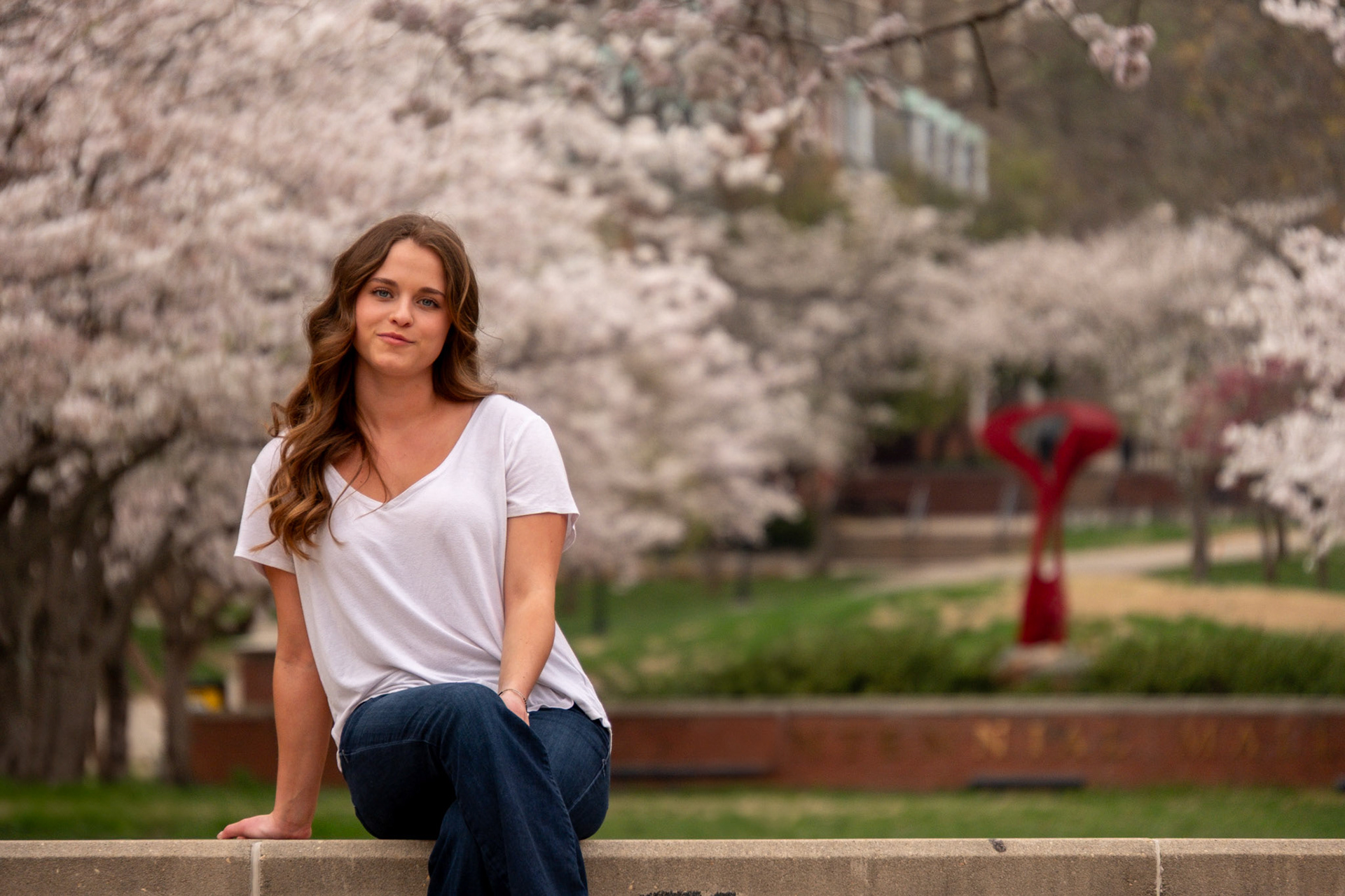 Olena Makhnovets, 18, poses in various locations across Western Kentucky University's campus on March 28, 2025. Following weeks of unpredictable weather, the campus was covered in white and pink as cherry blossom trees began to bloom.