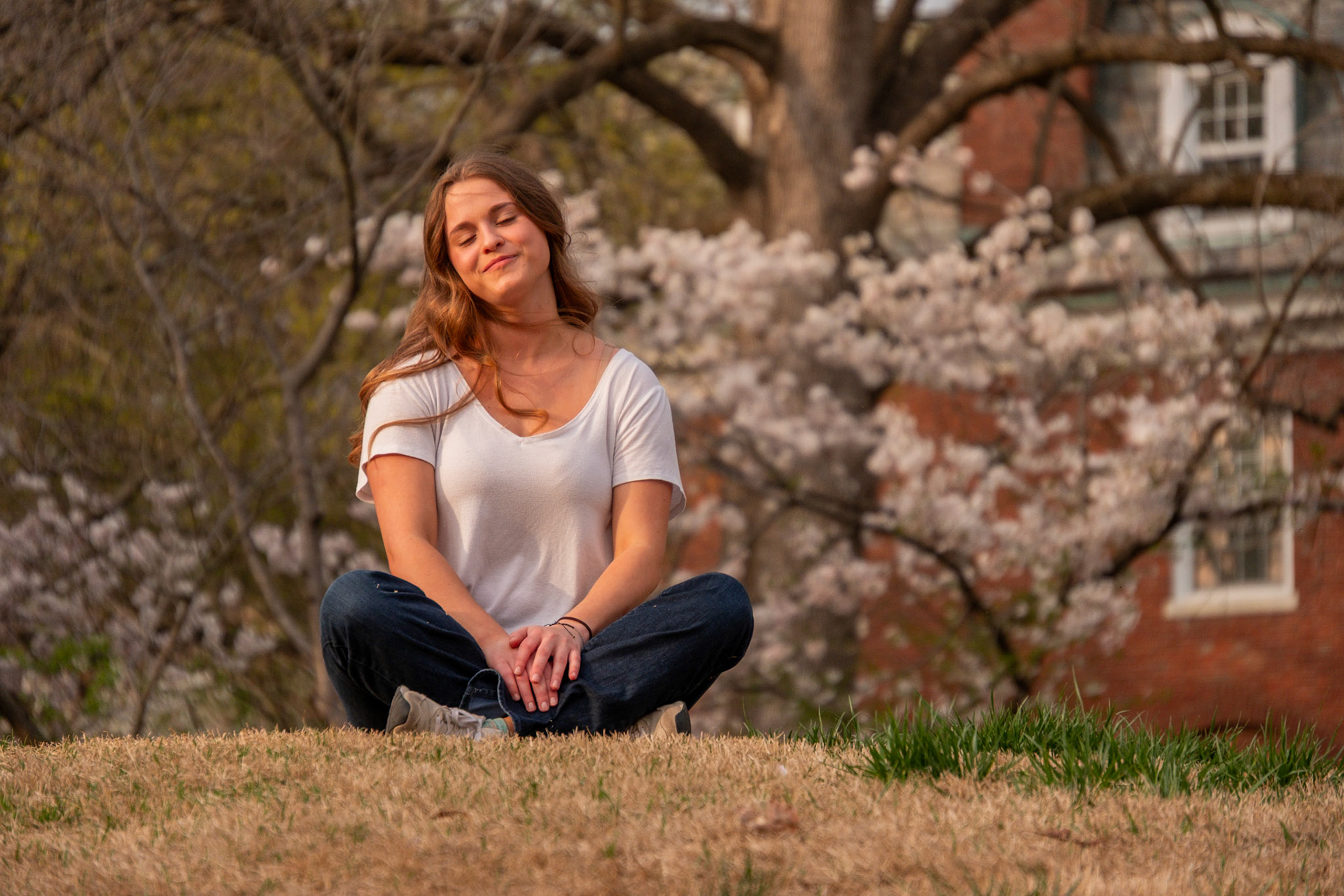 Olena Makhnovets, 18, poses in various locations across Western Kentucky University's campus on March 28, 2025. Following weeks of unpredictable weather, the campus was covered in white and pink as cherry blossom trees began to bloom.
