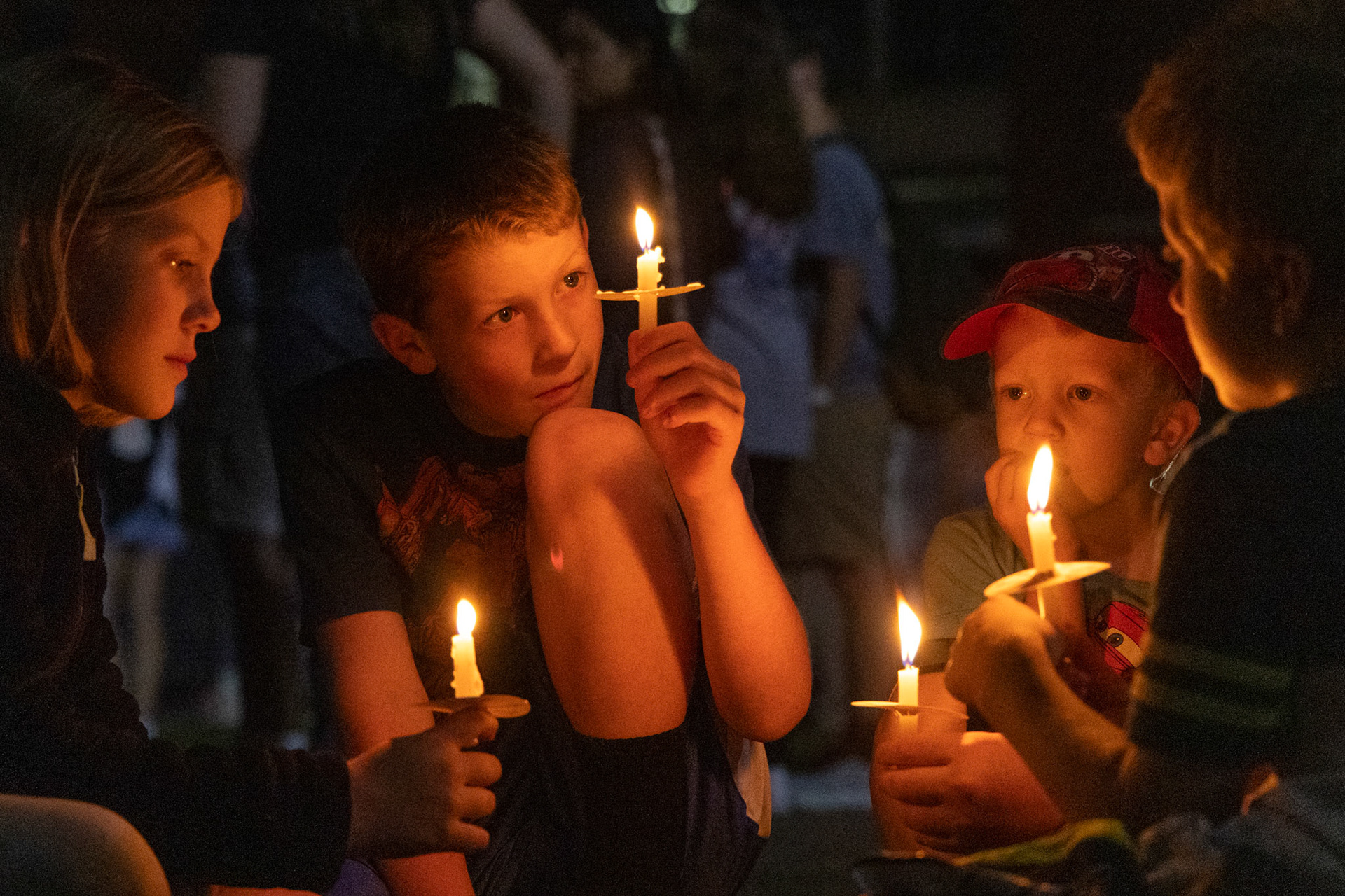 Hadassah, Bear, Josiah and Gideon Sweets sit in a circle holding candles during the WKU chapter of Turning Point USA’s vigil for conservative commentator Charlie Kirk on the South Lawn on Thursday, Sept. 25, 2025.