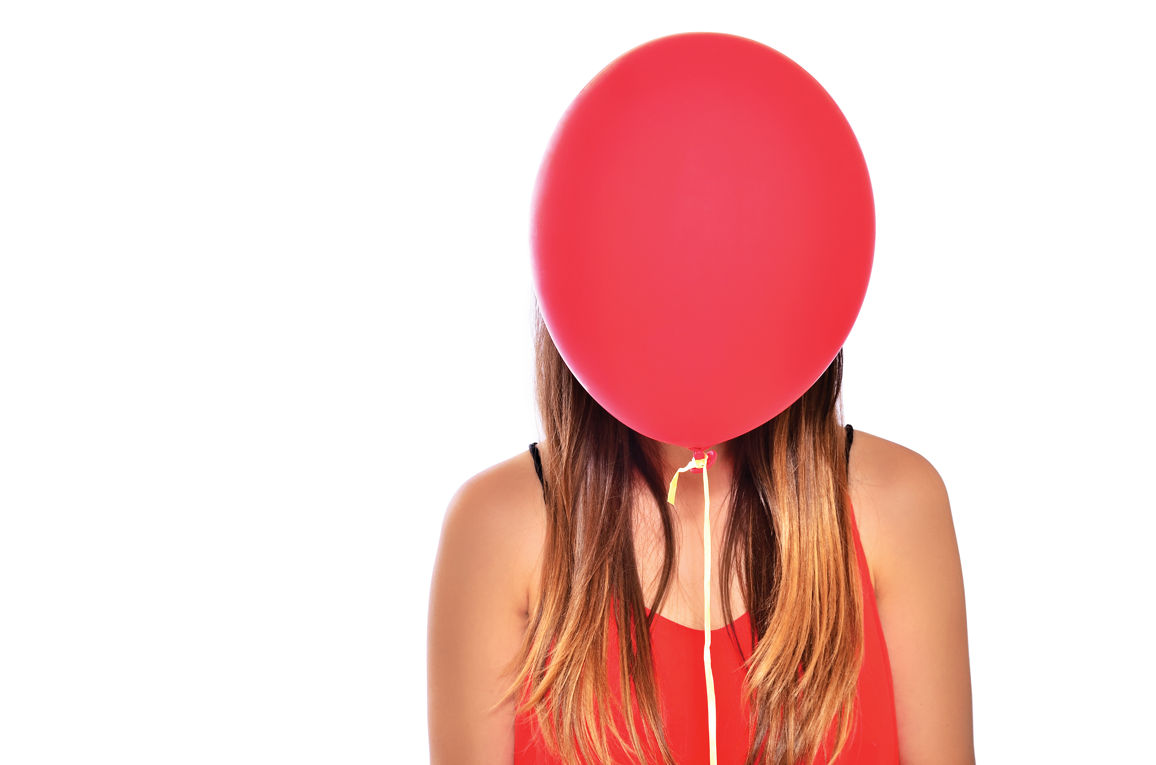 Brown haired model with red balloon in front of face studio lighting