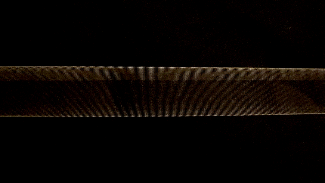 Animated gif of a closeup guitar string oscillating over a black background.