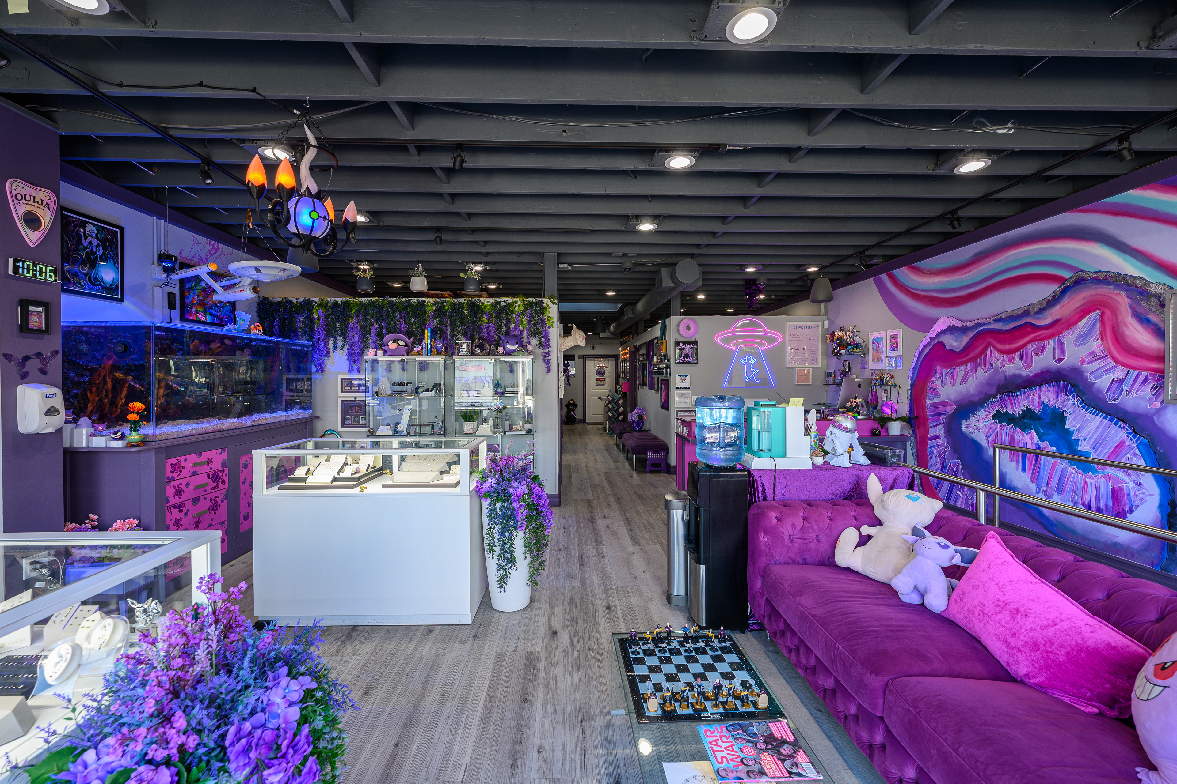 Studio interior with glass display counters, a purple sofa and colorful wall art