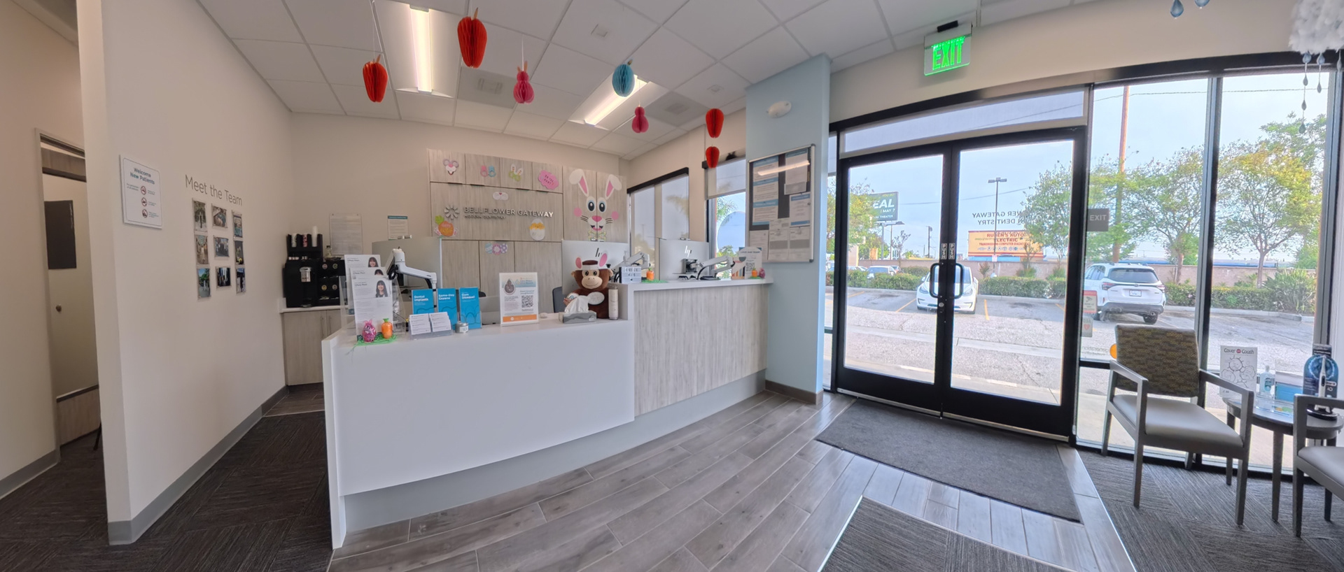 Reception area with a curved front desk, waiting chairs and a glass storefront entrance.