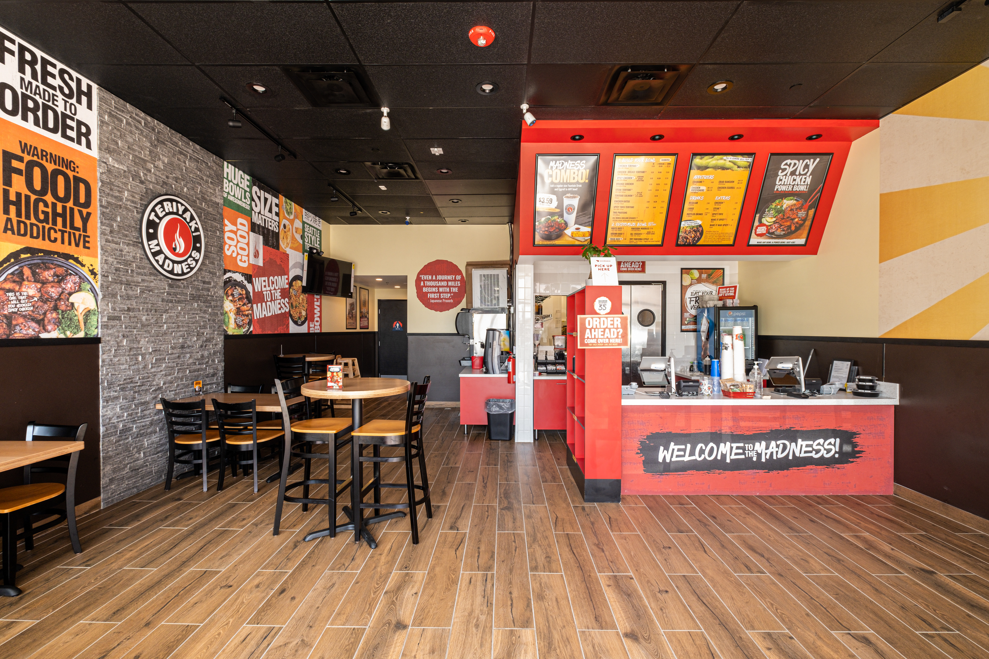 Restaurant interior with a service counter, overhead menus and dining tables