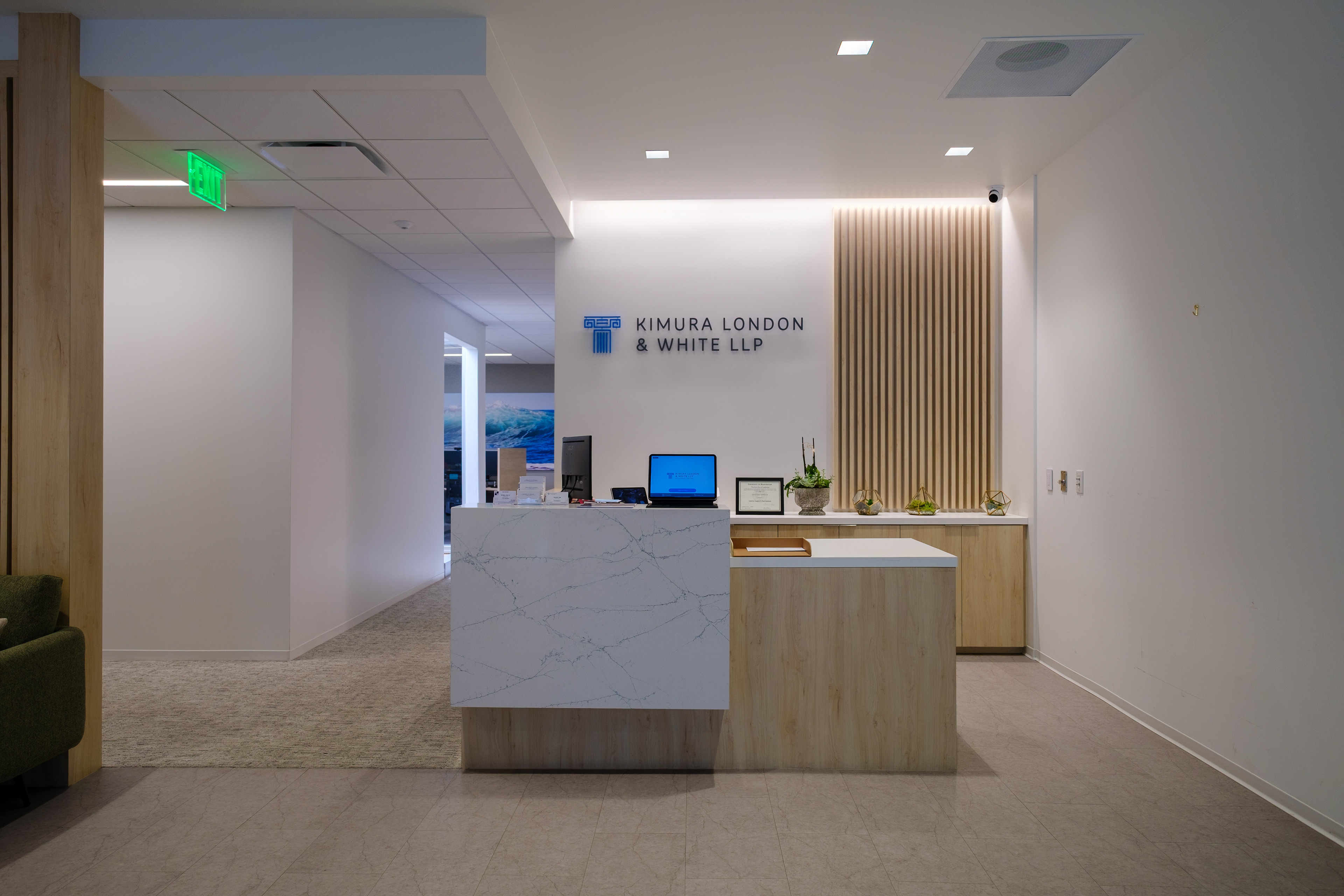 Office reception with a marble-front desk and wood slat feature wall