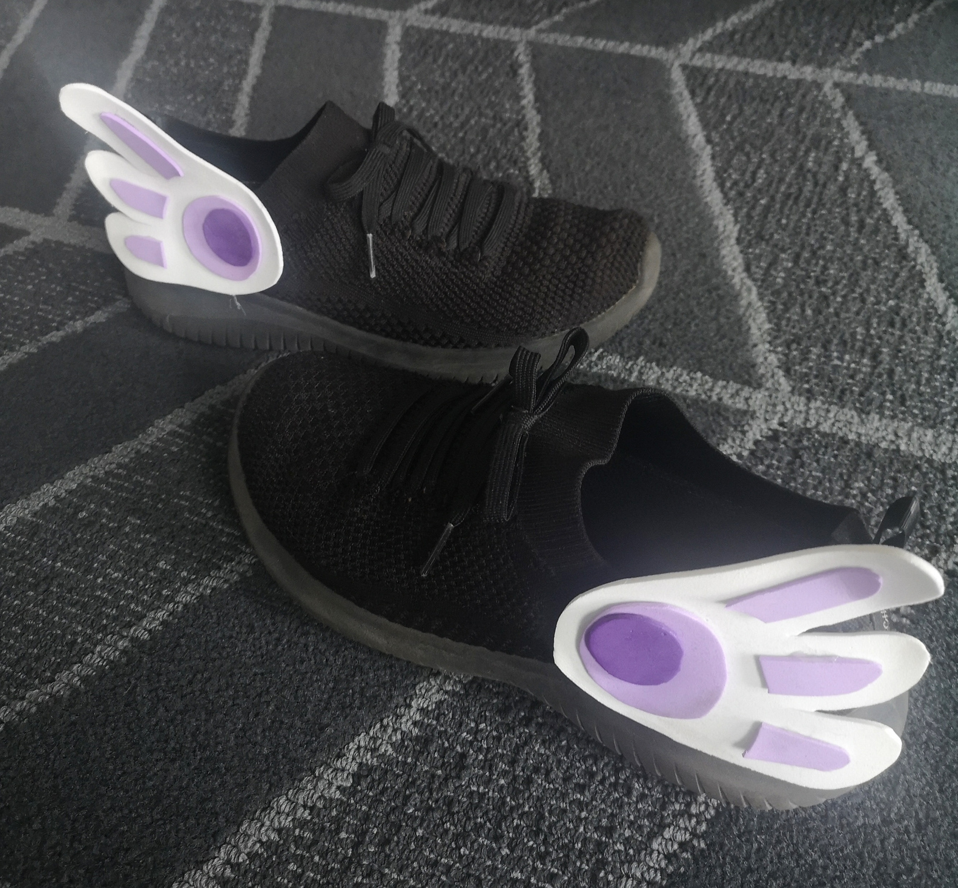 Black sneakers with white foam wings cut-out and purple circular accents