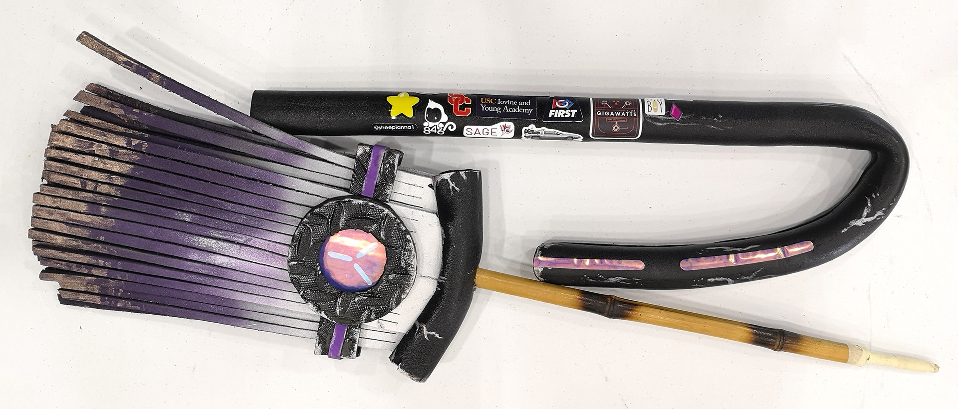 Disassembled foam broom with internal bamboo stick showing modularity to fit into suitcase