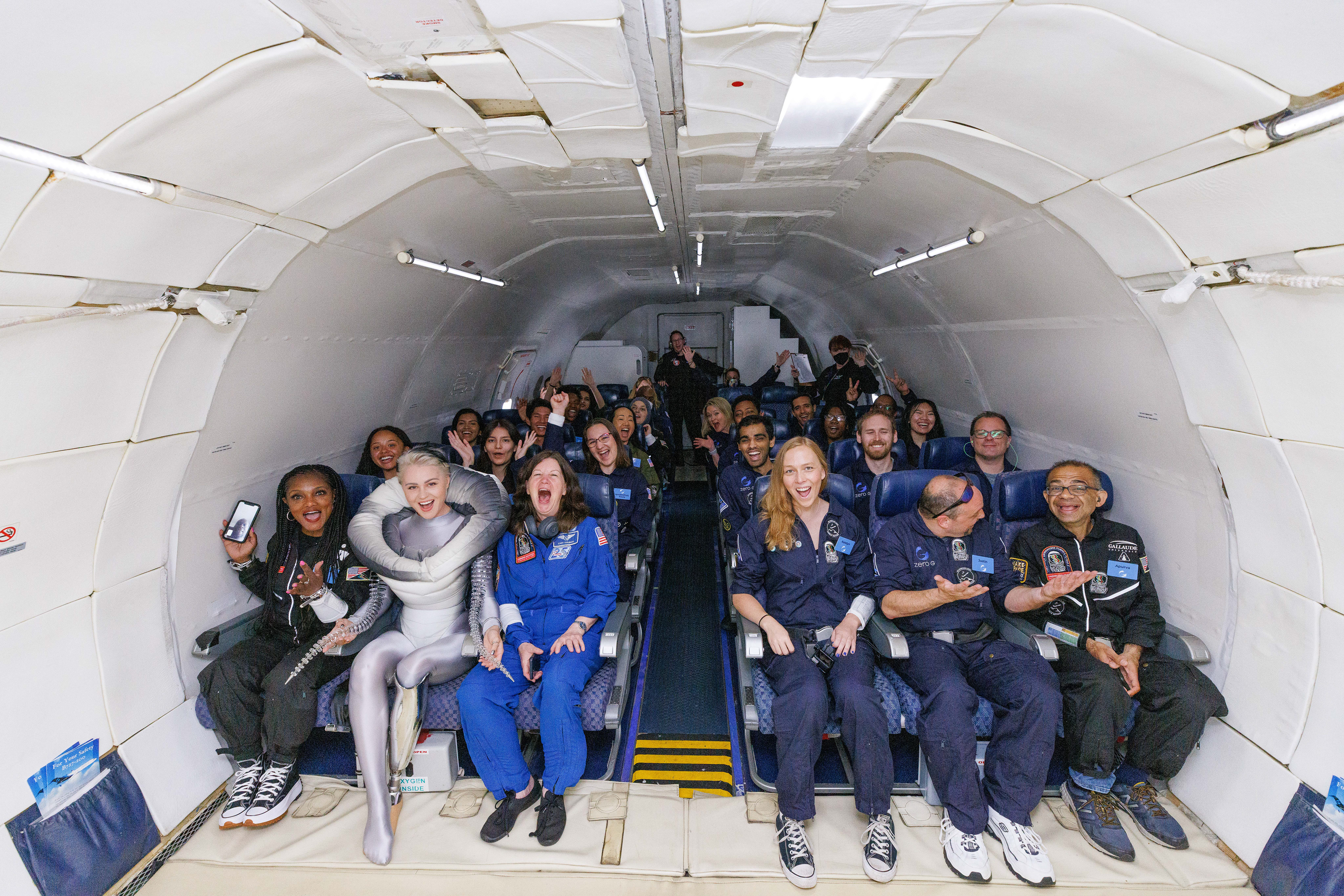The whole crew, all smiles, sits at the back of the plane in seats for take-off. Credit Zero G Corp and Steve Boxall