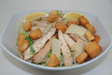 Ceasar Salad Romaine lettuce tossed with Caesar dressing, croutons, lemon, and parmesan cheese.