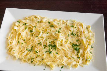 Chicken Fettucine Alfredo Cucina Fresca’s fettuccine, chicken, basil, home-made Alfredo sauce, and parmesan.