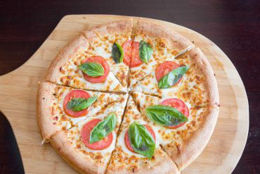 Margherita Pizza Olive oil base, fresh basil, garlic, tomatoes, parmesan, and mozzarella cheeses.