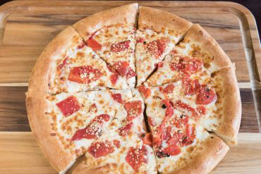 Drunken Goat Pizza Goat cheese, roasted red peppers, fresh garlic, mozzarella cheese, and pizza sauce.