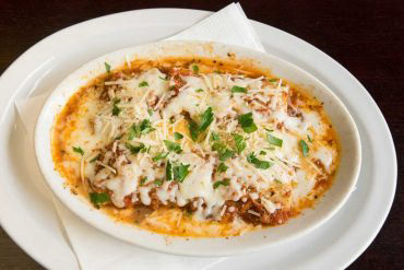 Baked Cannelloni Pasta stuffed with ricotta, parmesan, spinach, ground beef, house-made bolognese, and mozzarella.