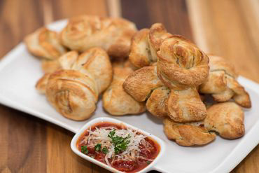 Garlic Knots Strips of our famous pizza dough tied up in little knots, stuffed with fresh garlic, olive oil, and parmesan cheese. Baked to perfection, and served with marinara sauce.