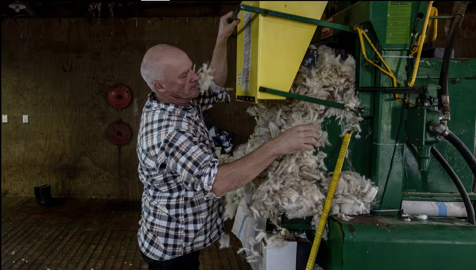 Mark Barrowcliffe loads a wool press on a farm near Piopio. Photo / Mike Scott