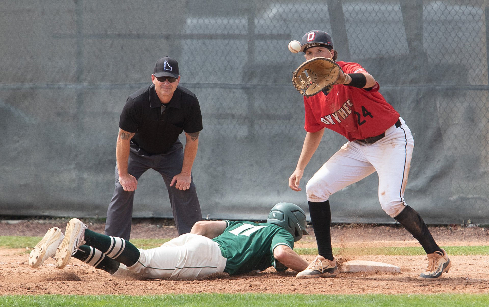 Eagle High Schools Brayden Lame (10) gets back to first base to beat the tag by Owyhee HIgh School's Shelby Pease (24) during district playoff game at Jack Acree Field on Saturday.