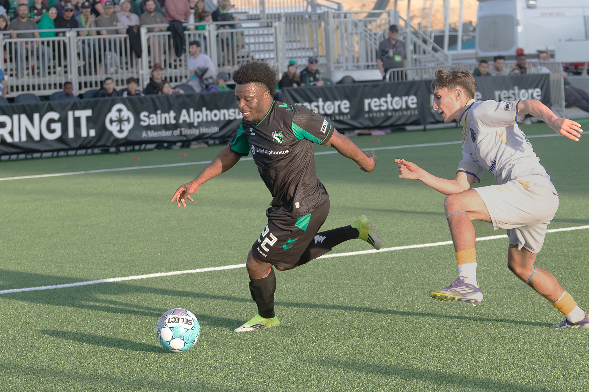 Thomas Amang (22) for Athletic Club Boise dribbles the ball with Kyle Evans (83) of Westchester Soccer Club defending during soccer match at Les Bois Park on Saturday.