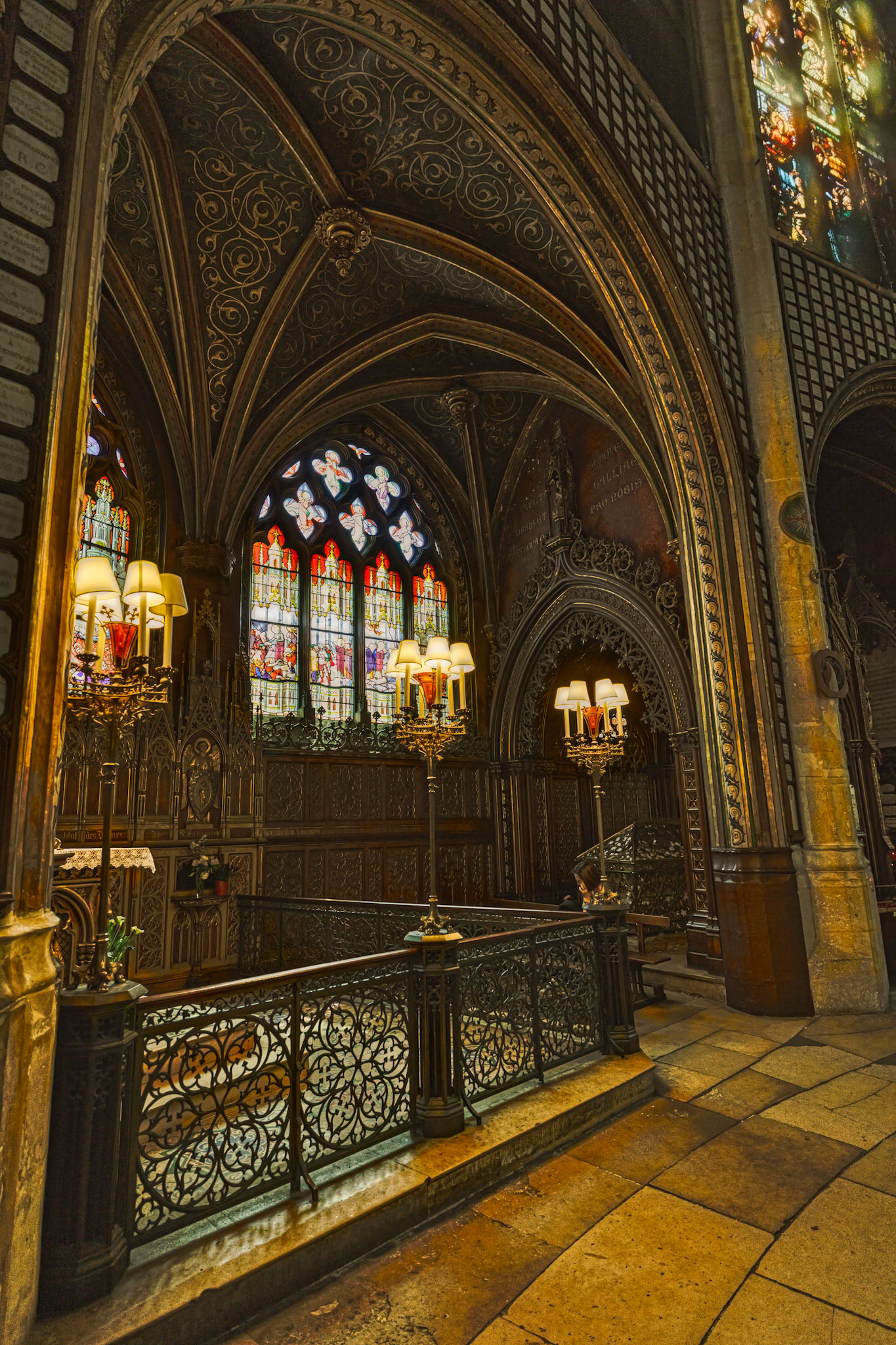 View of the altar framed by the stone colonnade and decorative chandeliers.