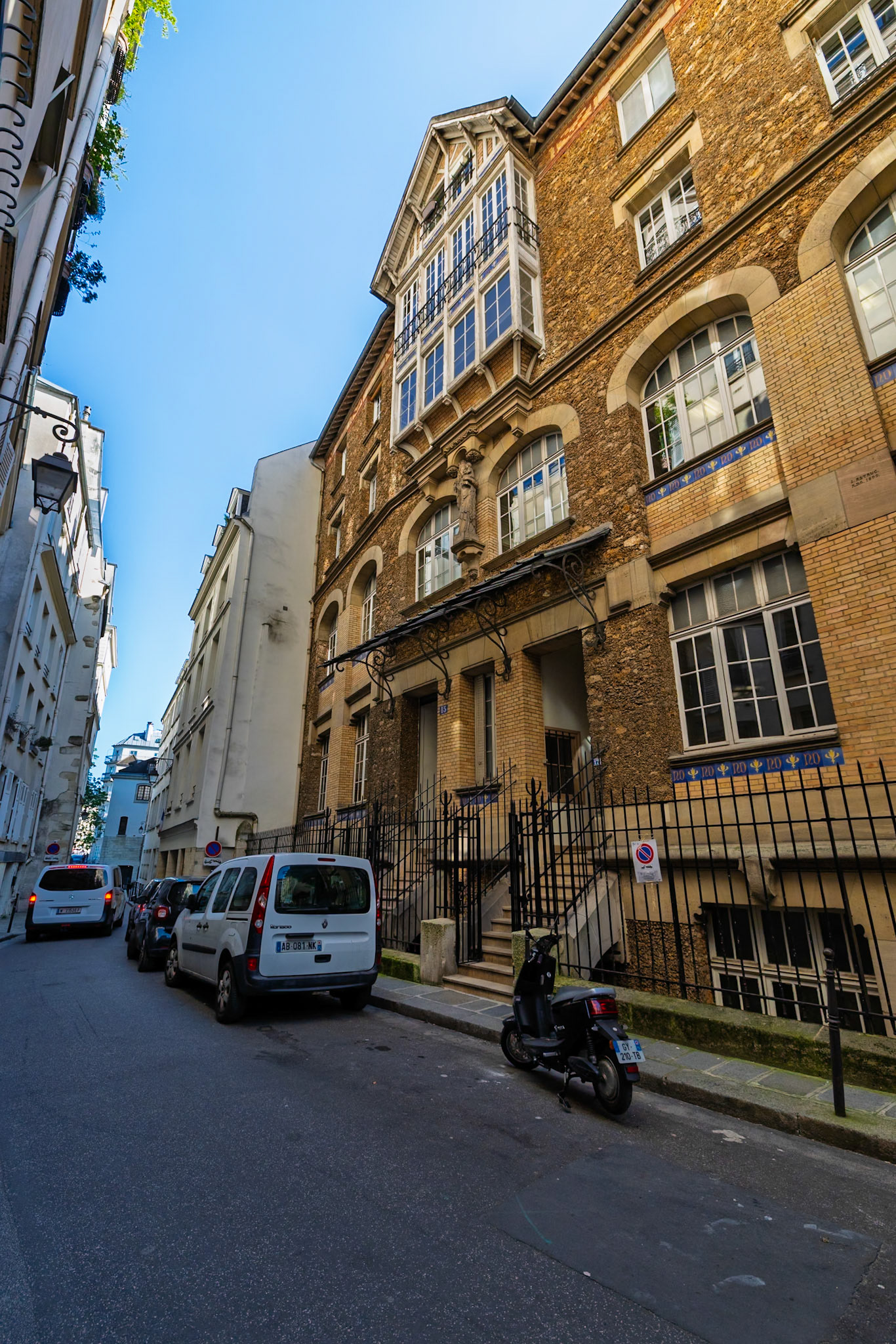 Tucked into the medieval lanes of Île de la Cité, this early 20th-century primary school carries the legacy of the Ursuline nuns who once taught here. Its brick and limestone facade, decorated with blue and yellow tiles, stands under the quiet gaze of a Republican statue above the entrance, embodying France’s enduring commitment to public education in the historic heart of Paris.