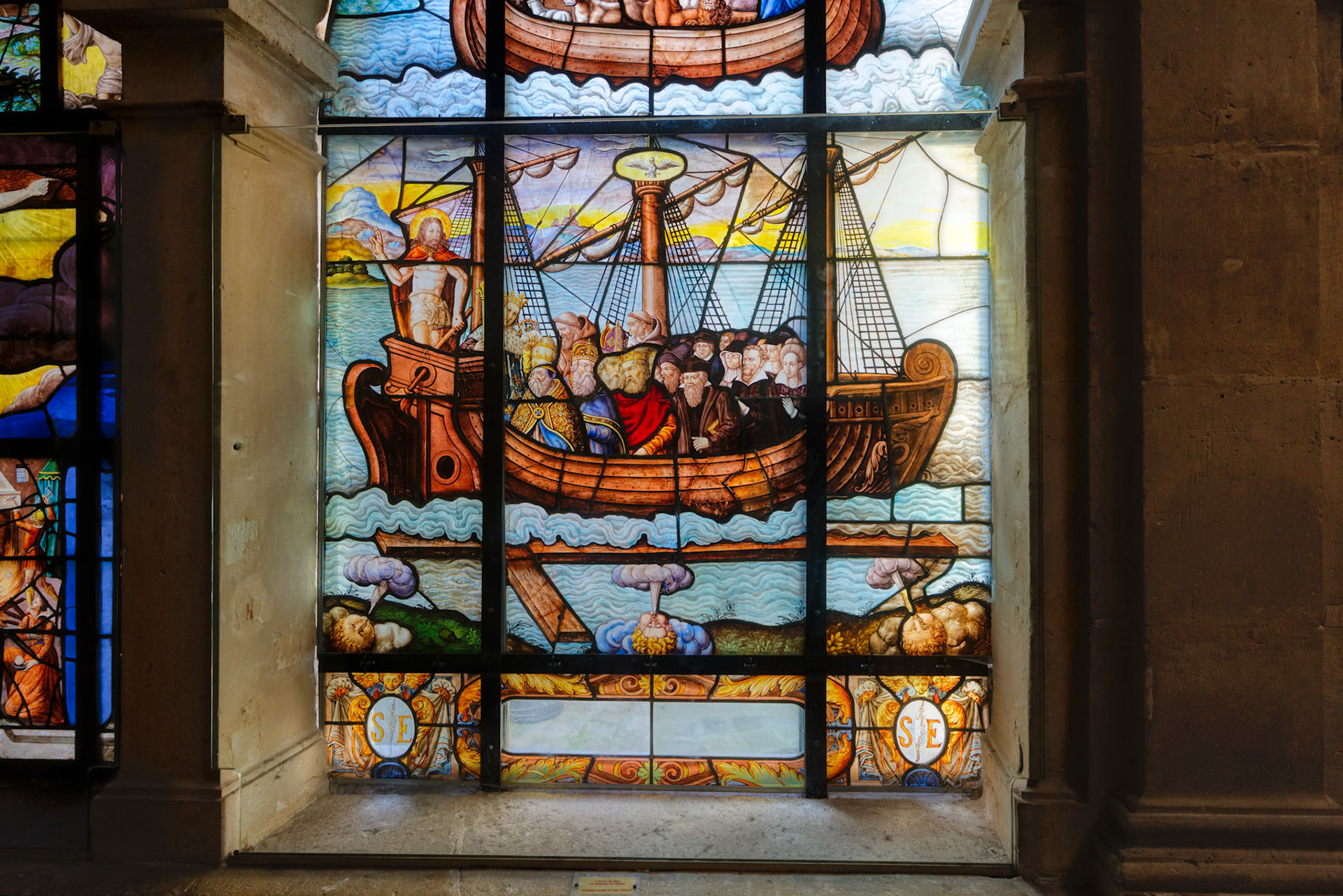Stained-glass detail shows a boat carrying saints and clergy â€” a metaphor for the Church.