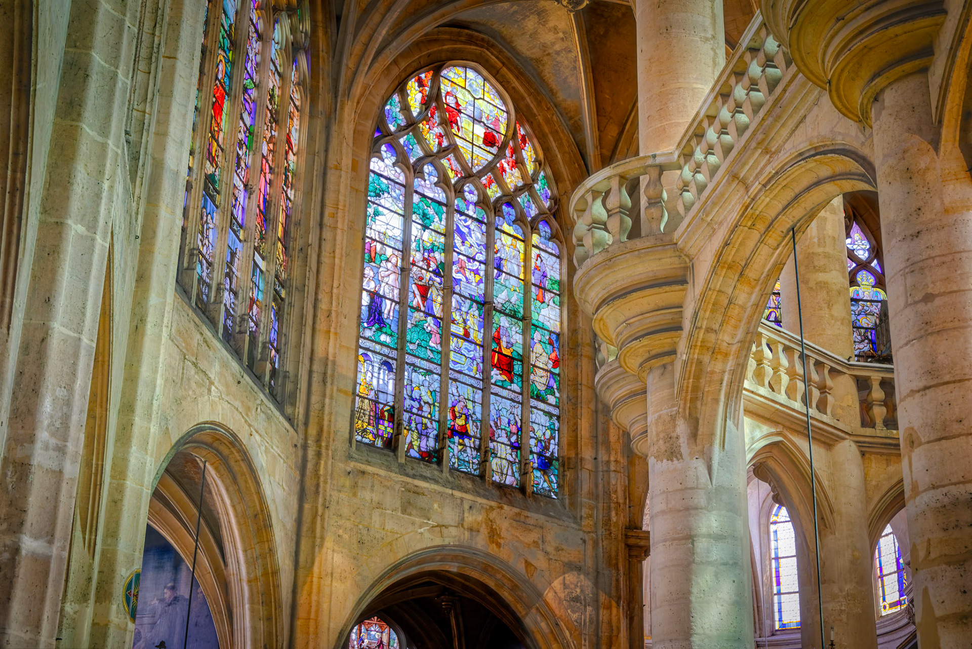 Close view of luminous stained-glass windows, showcasing biblical stories in vibrant detail.