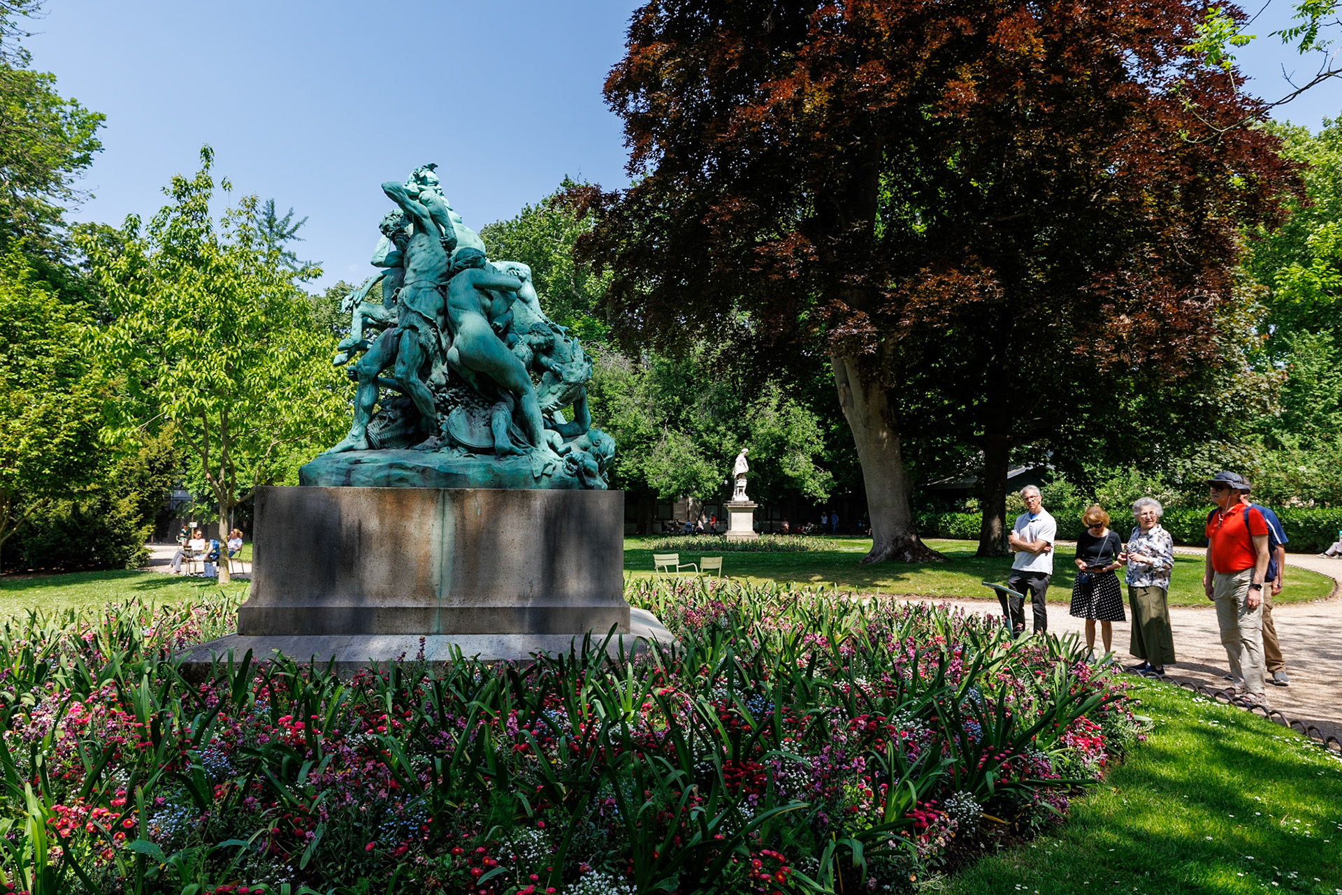 The sculpture portrays Silenus, the inebriated foster father and companion of Dionysus, the Greek god of wine. Depicted as a nude, drunken figure, Silenus is shown staggering atop a donkey, supported by satyrs and a maenad. The composition forms a pyramidal tangle of human and mythological forms, capturing the chaotic energy of a bacchanalian procession