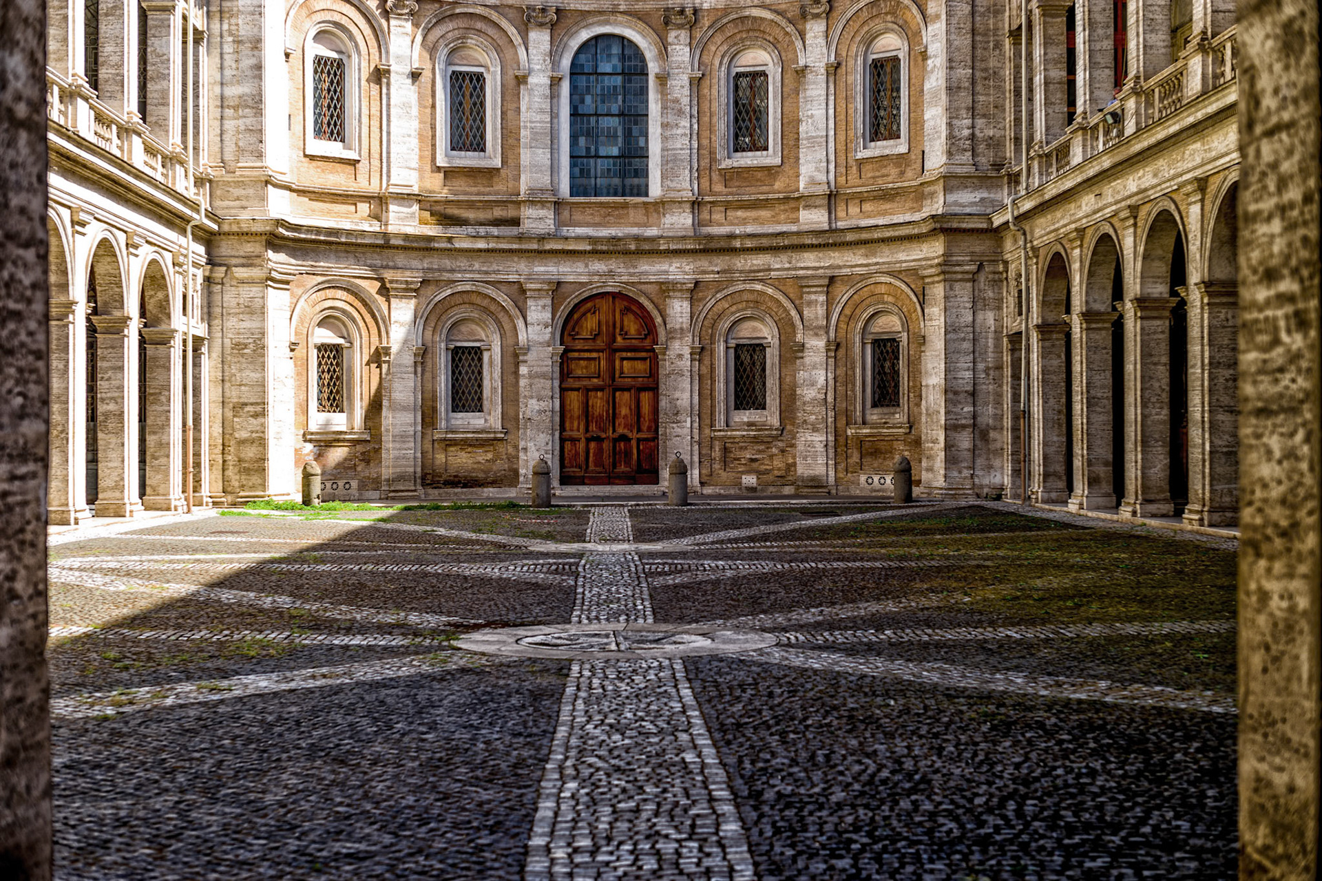 Palazzo della Sapienza was created in 1587 by Giacomo della Porta in the order of Pope Sixtus V. Until 1935, it was the headquarters of the "Sapienza", the University of Rome, which was founded in 1303 by Pope Boniface VII. The door at the far end is an entrance to Roman Catholic church named Sant'Ivo alla Sapienza.