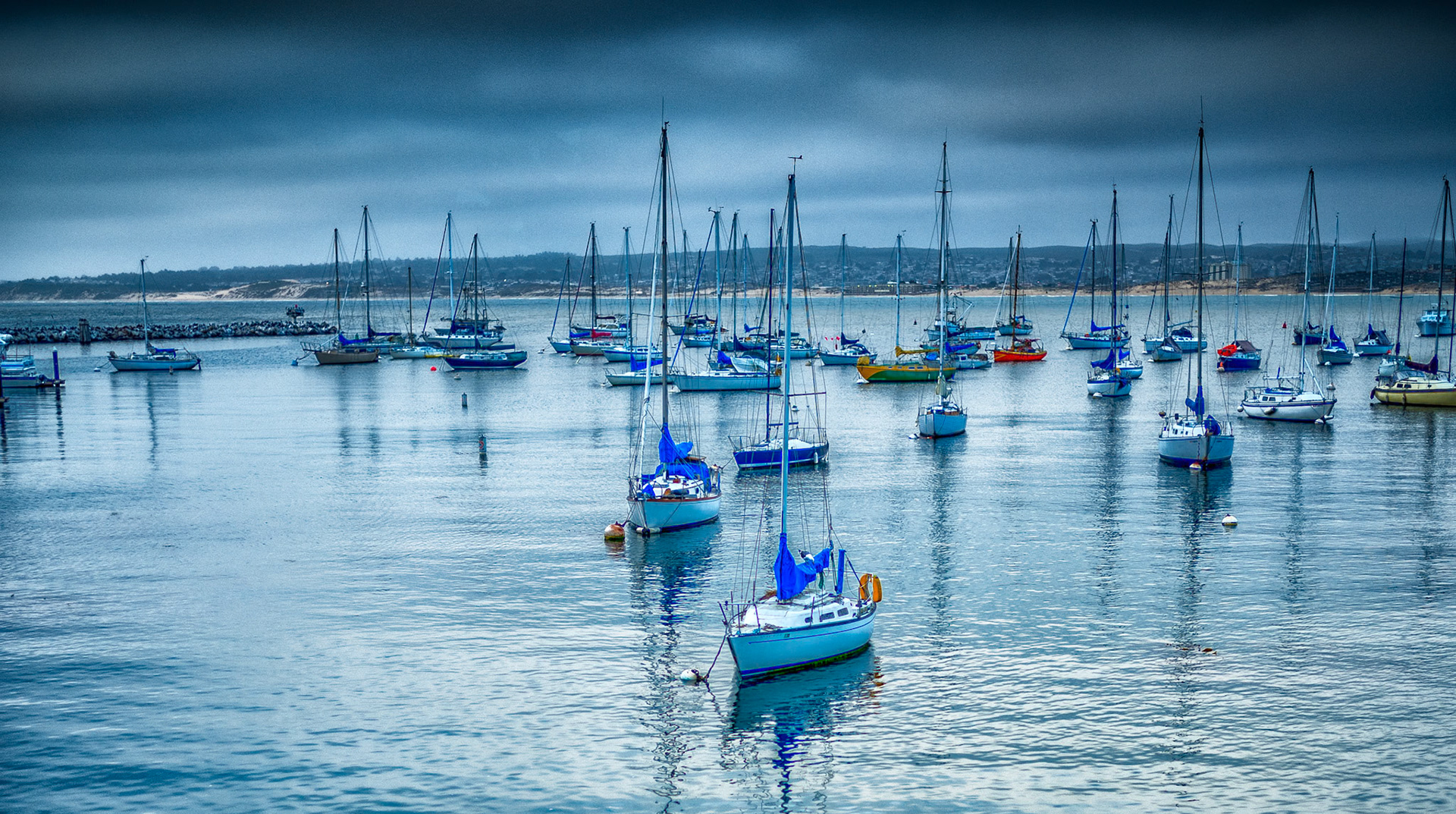 Monterey Harbor with the Monterey Bay in the background on a typical overcast day.  I love the calming effect this picture has on me and in thinking about the many adventures taken on the pictured sailboats and the many that came before.