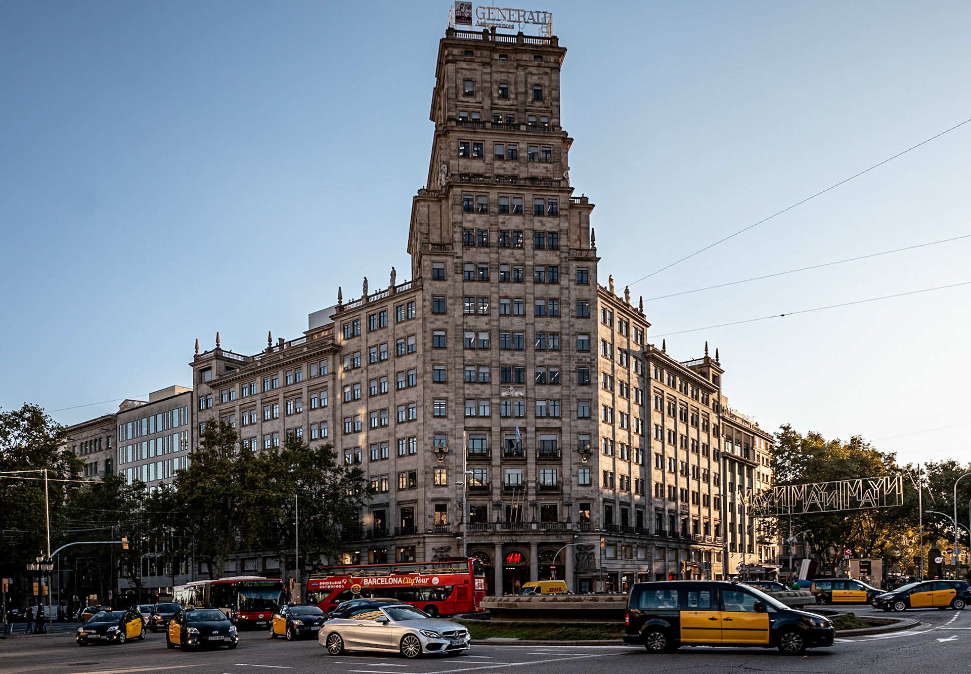 Love the afternoon lighting hitting the building and many autombiles in this busy roundabout in Barcelona, Spain.