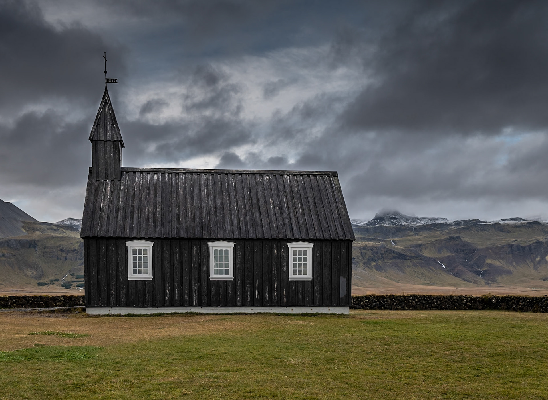 Located on the south side of Snæfellsnes Peninsula, Iceland. Búðakirkja is a local parish church still operational today and dates back to 1703. Tucked away from the hustle and bustle, this quaint black church is one of the most photographed churches in Iceland.