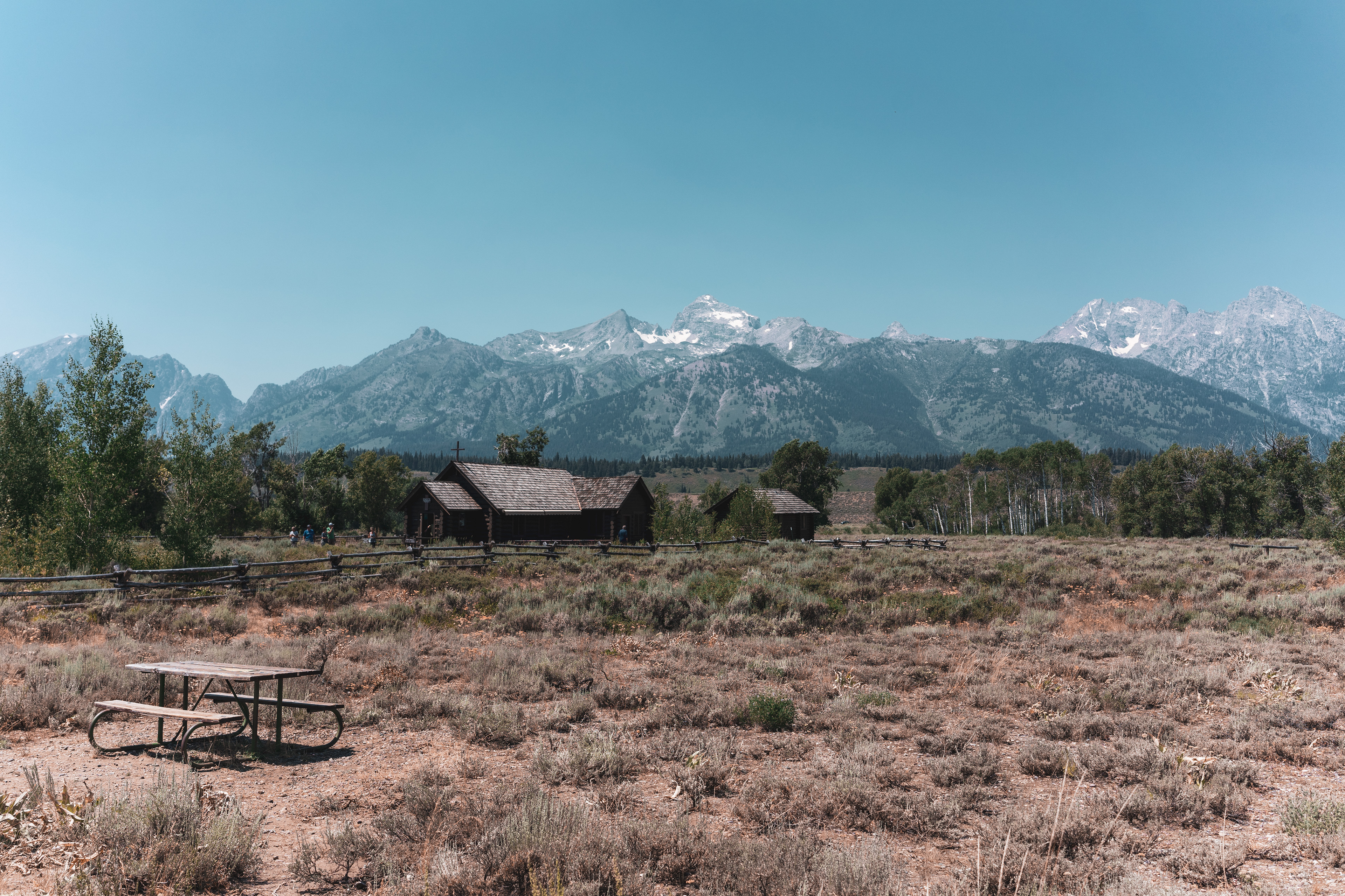 Fine art landscape photo of a rustic cabin with the Grand Teton mountains in the background. 