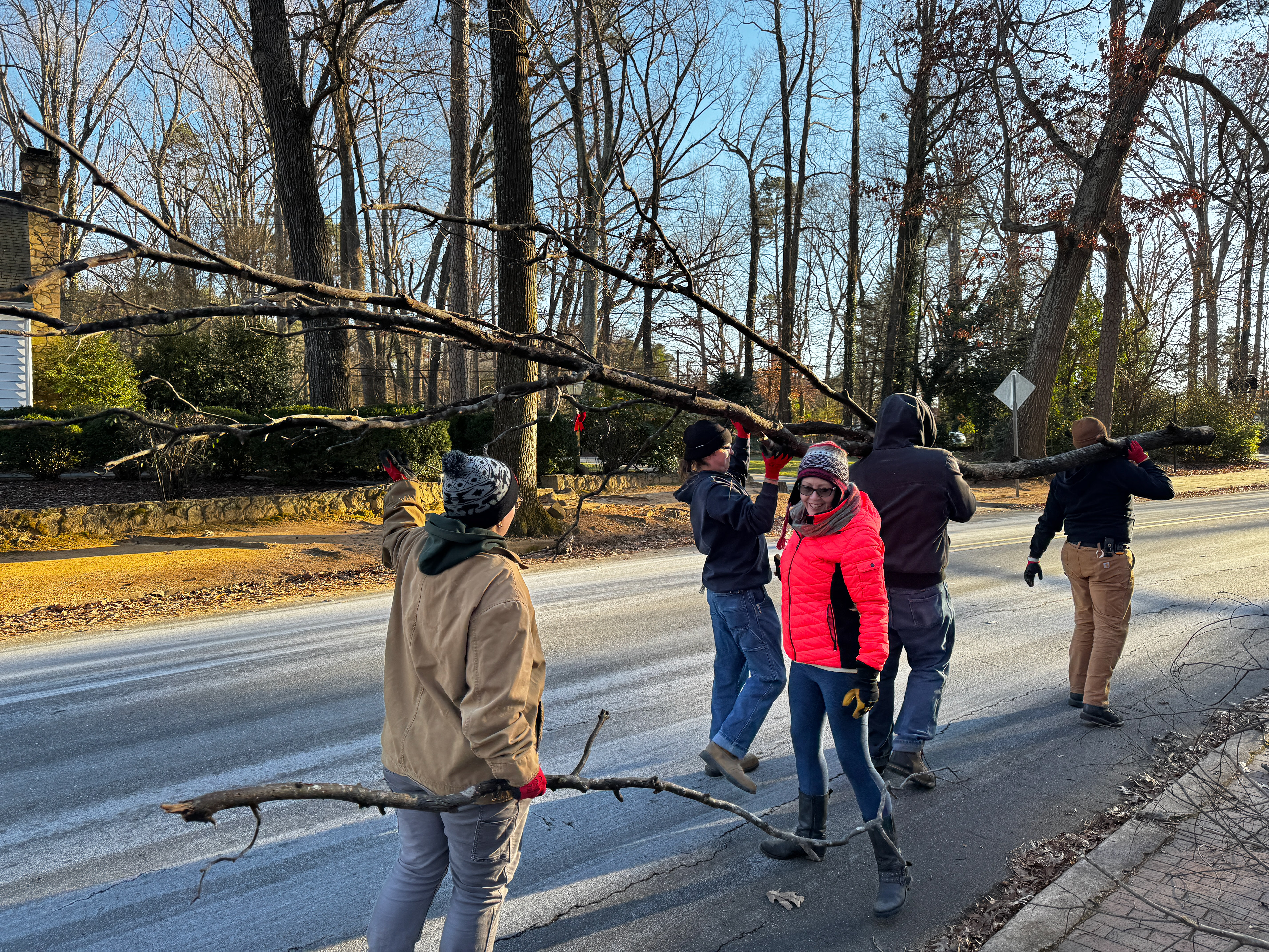 TD Laura, Designer Jan, & Carpenters Roark, Alec, & Ben retrieving dead branches from the woods on Laura's property