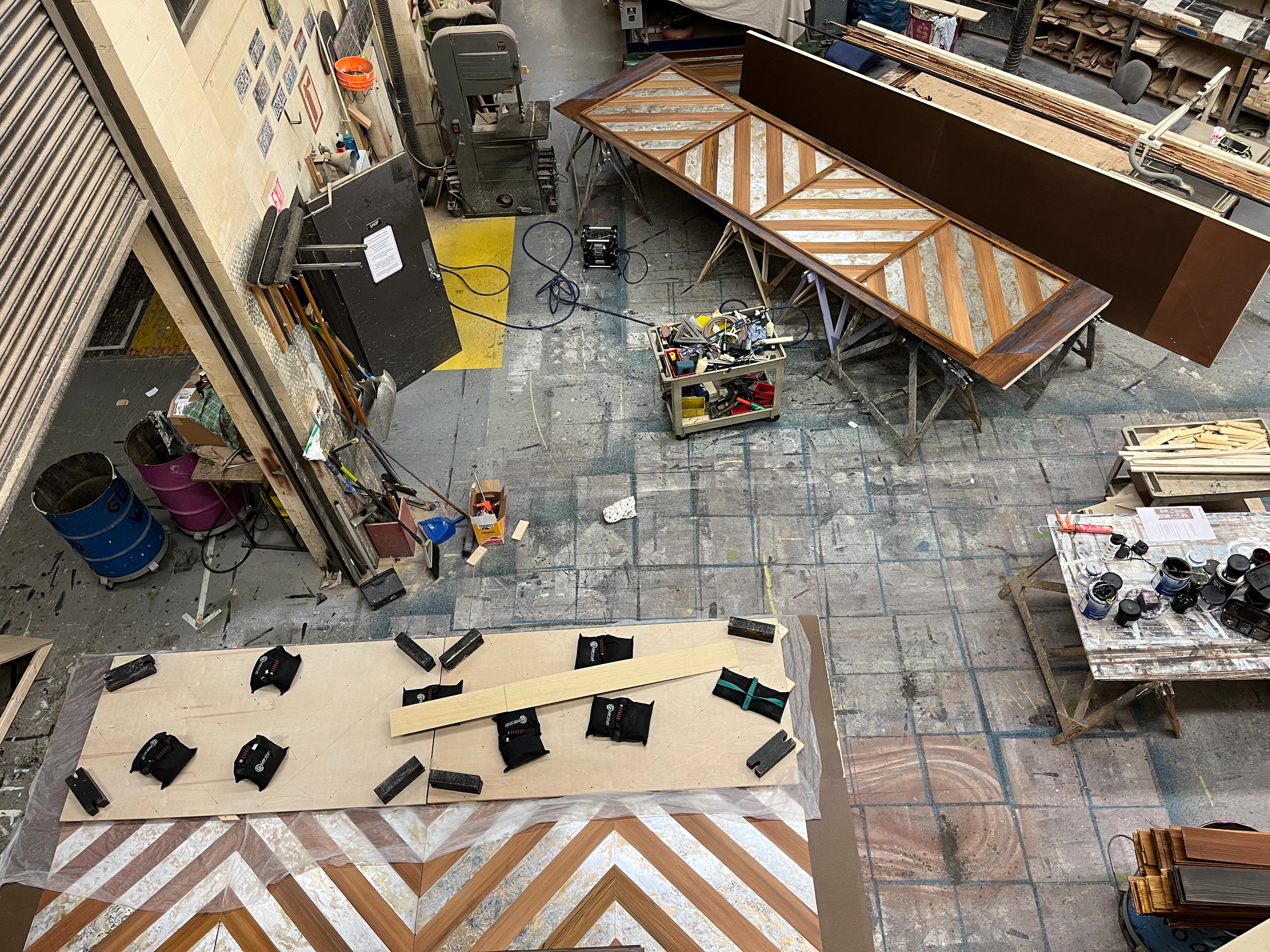 2x4's were screwed on plywood in the chevron pattern to weight down mirror panels evenly while liquid nails cured.