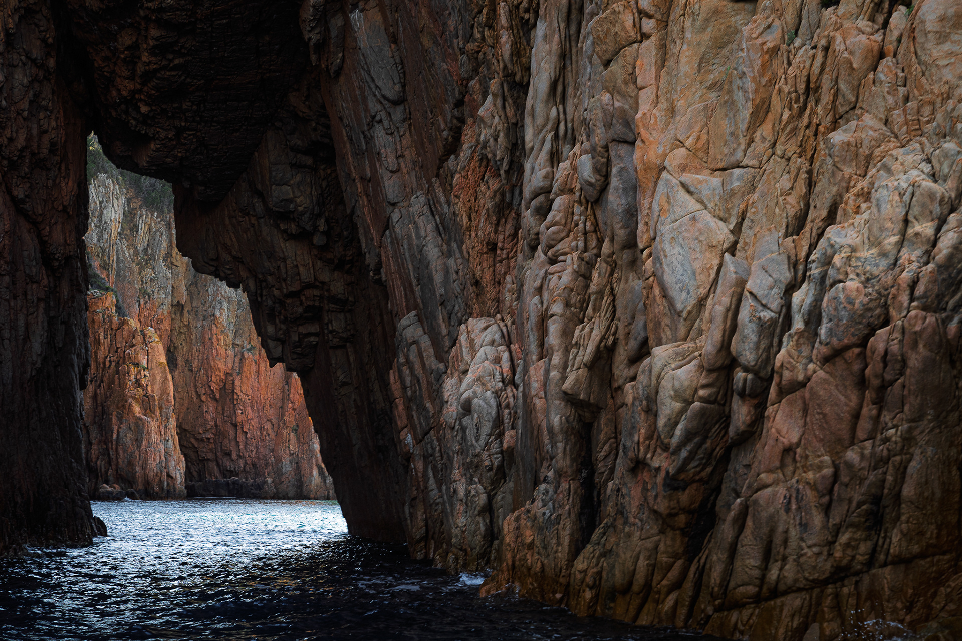Archway of striking red granite in the Calanques de Piana