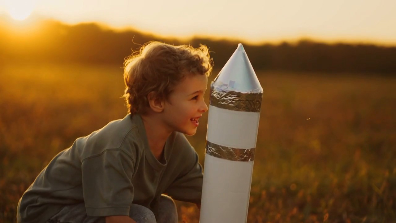 Enfant jouant avec une fusée dans un univers d’imaginaire