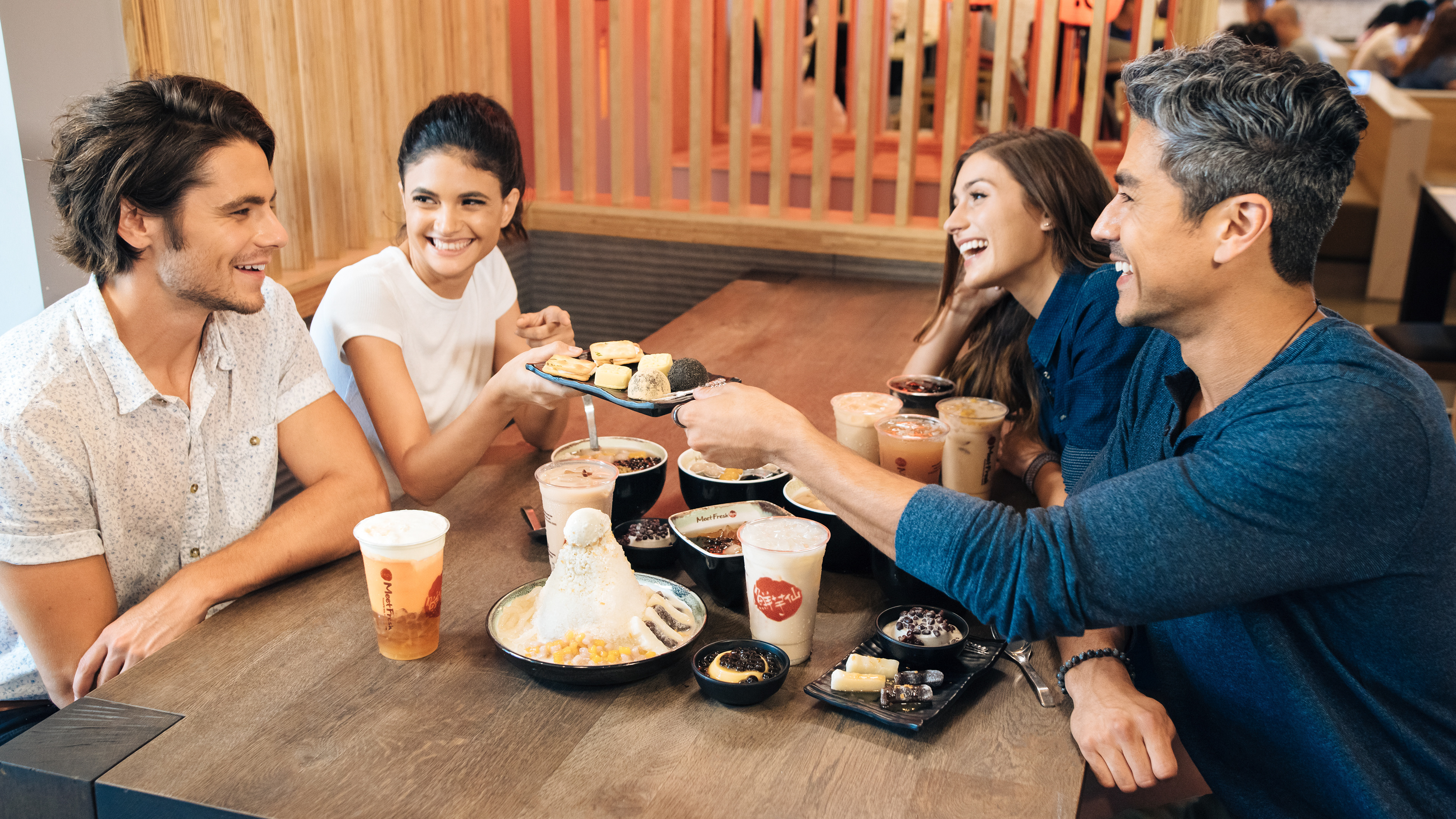 Verified Human Capture by Haoyuan Ren. Commercial brand campaign for Meet Fresh hospitality. This image documents diverse human interaction and interior brand presence through a non-synthetic, optical in-camera record in Southern California. Large-scale production-ready asset for in-store display; documented via authorized observer access to the hospitality environment.